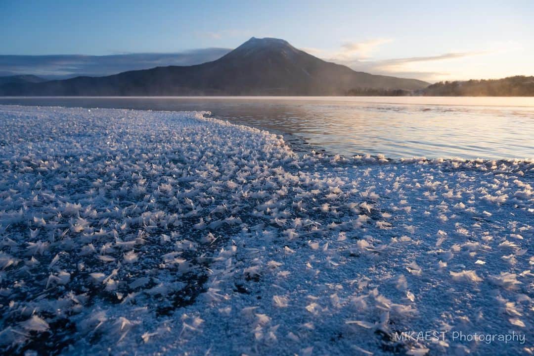 mikaestのインスタグラム：「Frost Flower in Lake Akan 阿寒湖のフロストフラワー❄️  フロストフラワーが見られる時期に行ったのですが ちょうど前夜に雪が降って 凍った湖面が真っ白になってしまいました。 あぁ、フロストフラワーは見れないなぁと 宿泊先で温泉三昧をしていました笑笑  ただ、翌朝かなり冷え込む予報だったので、 何か起こるかもと朝方に湖畔へ行ったら フロストフラワーを見れました!!!  やはり撮る前に諦めちゃだめだし、 現場に行かないと始まらないし、 現場に行けば楽しいなぁと、 改めて感じた次第です😊  ちなみにチェックインからチェックアウトまで、 温泉は5回入りました♨️  Camera : Nikon Z7 Lens : Nikkor Z 24-70mm f/2.8 VR S  #Zcreators #阿寒湖 #フロストフラワー #雄阿寒岳 #sunrise #阿寒国立公園 #nationalparksjp」