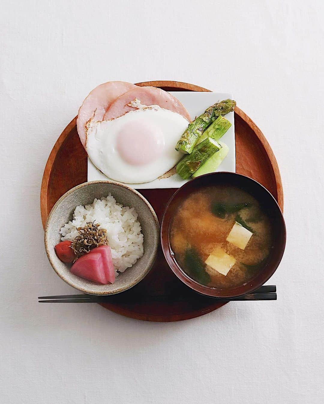 樋口正樹さんのインスタグラム写真 - (樋口正樹Instagram)「Today's breakfast . 今朝は炊き立てごはんに 梅、赤かぶ漬け、じゃこ、 わかめと豆腐のお味噌汁、 ハムエッグにお醤油数滴、 アスパラは卵黄をつけて。 . . . #朝食 #朝ごはん #目玉焼き #ハムエッグ #豆腐の味噌汁 #わかめの味噌汁 #breakfast #japanesebreakfast #washoku」2月26日 8時23分 - higuccini