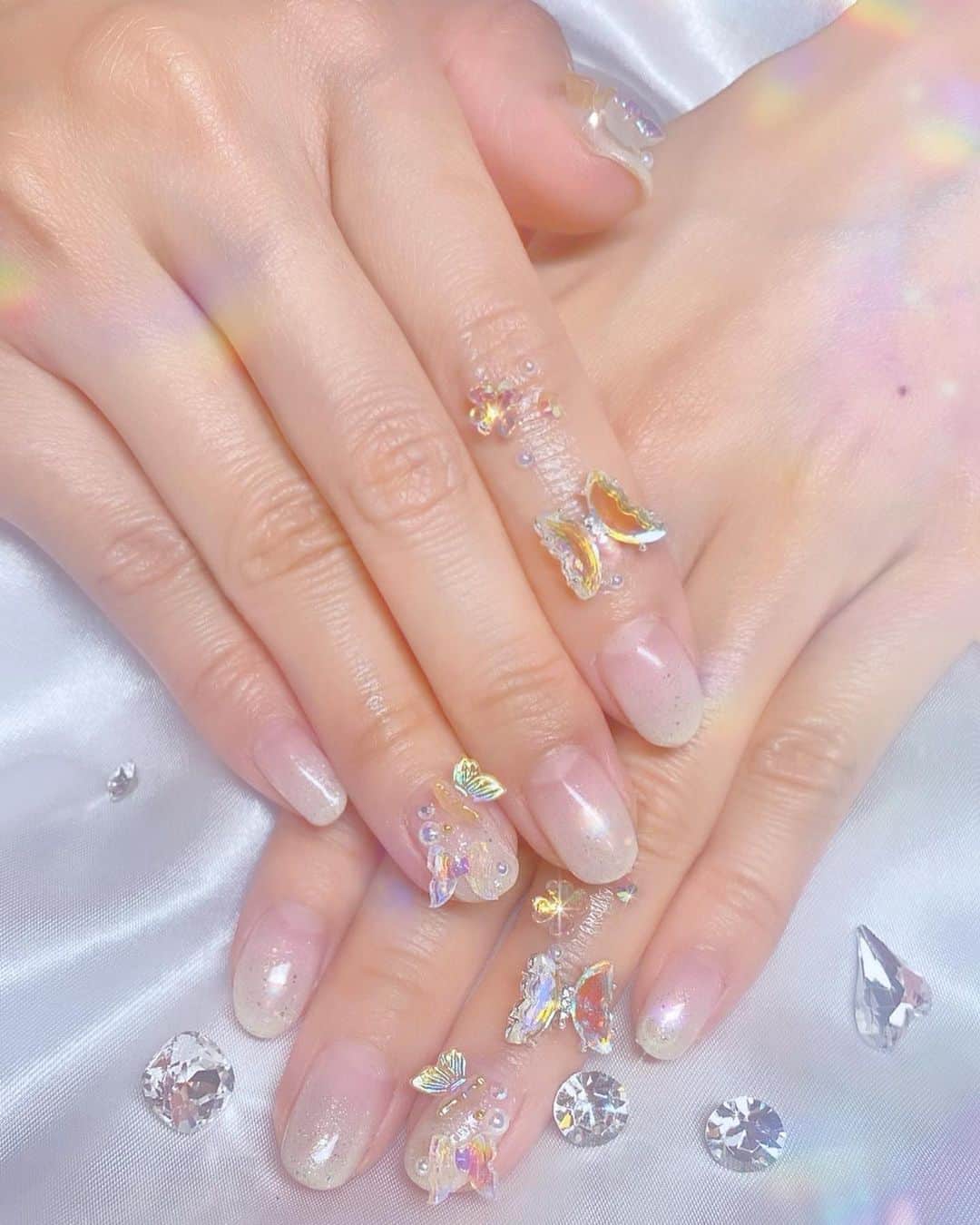 明日花キララのインスタグラム：「白ドレスに合うちゅるちゅるバタフライにしました🦋🤍 ネイルサロンに行った日は指までがネイルなので指も可愛く盛り付けした🦋👼🏻💎👼🏻💍 #指までがネイル」
