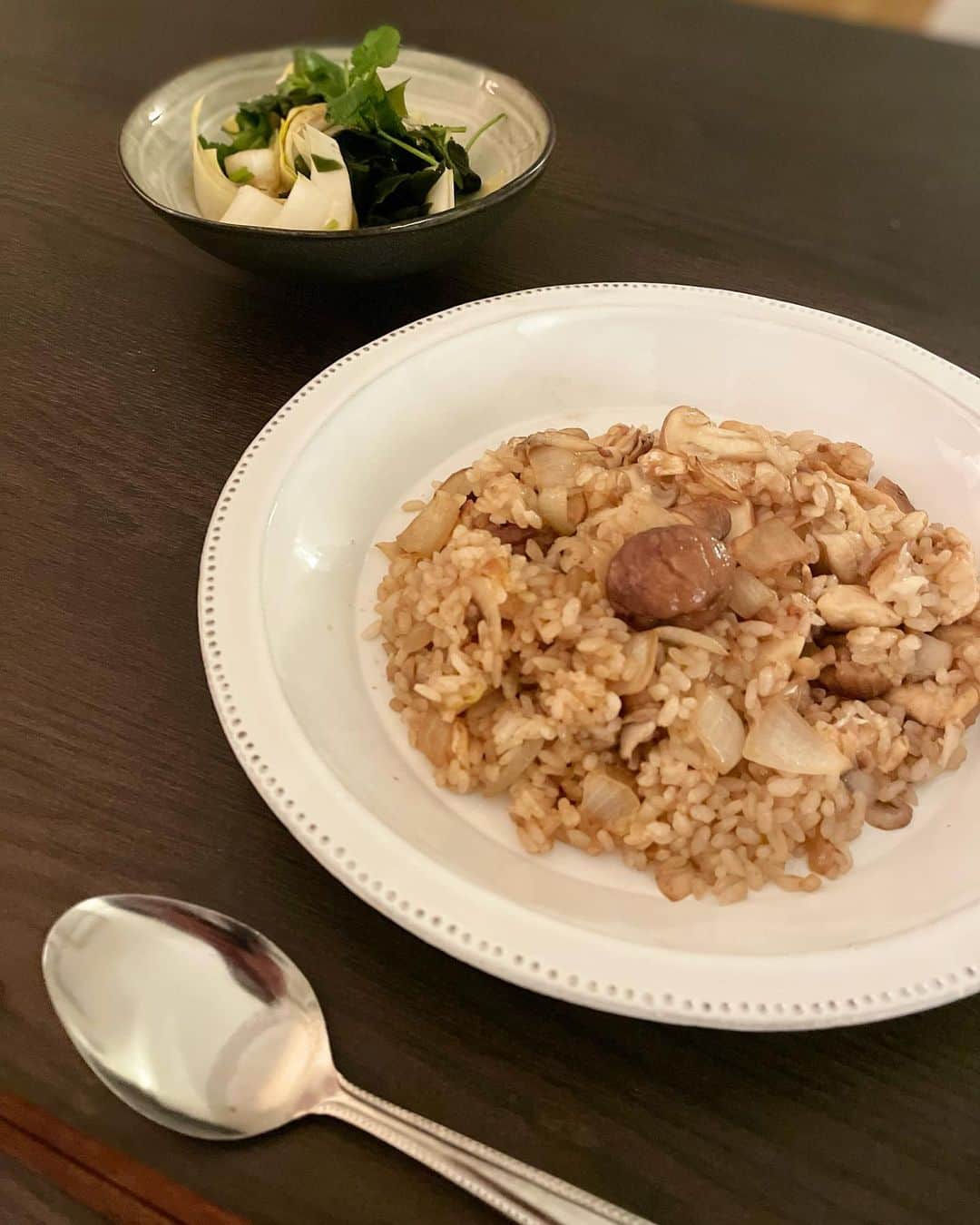 のインスタグラム：「シリーズ《鬼の居ぬ間に洗濯😏》  彼不在の夜は、たいてい猫沢飯の実験場となる。今夜は、はじめ何が食べたいのだか自分でもよくわからなかったのだけど、冷蔵庫の栗ストックを見つけた途端、閃いた(*✧×✧*) これだ❣️  鶏と栗と茸の醤油バターライス。この組み合わせで美味しくないわけがない。玉ねぎは大きめの賽の目に切って、少しのにんにくとよく炒めて。鶏、栗、茸を投入したら白ワインを振って旨味を栗に吸わせる。  うーん……で　り　す　ゅ　ー　😍  副菜は、わかめとアンディーヴ（チコリ）とコリアンダーの三杯酢。アンディーヴの苦味と三杯酢の甘辛がステキなマッチング。  ふたり飯が多くなった昨今でも、ひとり飯を作る楽しみ、食べる楽しみも俄然健在。ひとり飯は孤独飯なんかじゃない。ひとり飯という、ひとつの楽しみのジャンル。  #猫沢飯　#ねこしき　#猫パリ　#猫沢エミのインターナショナル五十路ライフシフト  #猫沢エミリーパリへ行く」