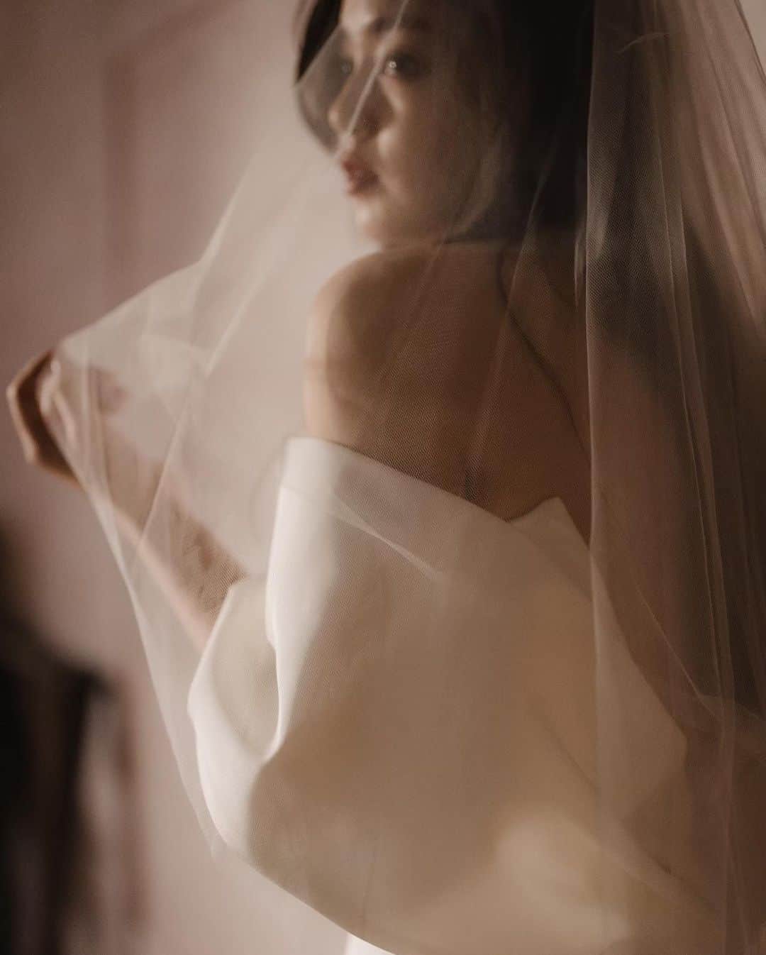 青柳文子のインスタグラム：「@juno_weddingdress の撮影👰🏻💍  3着目 @リストランテ ル・ミディ ひらまつ  INES DI SANTOのドレス👰🏻  シルクタフタの潔くクリーンな素材感と、 女性の体のラインを最大限に美しく魅せてくれるしなやかなマーメイドライン。  ボディを優しく包んでくれるようなデザインのオフショルダーはデザイン性だけでなく、ドレスを纏ったときの安心感も抜群。  くるみボタンが贅沢に施されたバックスタイルも素晴らしいです。。！  これ、個人的にすごく、体型カバーできていいなとおもいました。。！  #juno #junowedding #junoweddingdress @juno_weddingdress @juno_osaka」