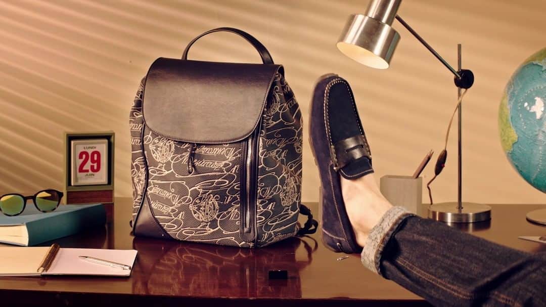 ベルルッティのインスタグラム：「- THE #BERLUTI SUMMER 2022 COLLECTION -   Just in time for the weekend: mixing a Scritto Arabesque jacquard with a soft leather flap, drawstrings and shoulder straps, the new Nomad backpack is the perfect lightweight yet resistant bag to take you from the office to an OOO adventure. Just as the Eclipse sunglasses and the new Saturnin loafers, blending a comfortable rubber outsole with a suede upper with Scritto leather details.   Now available in-store and on the e-shop.」