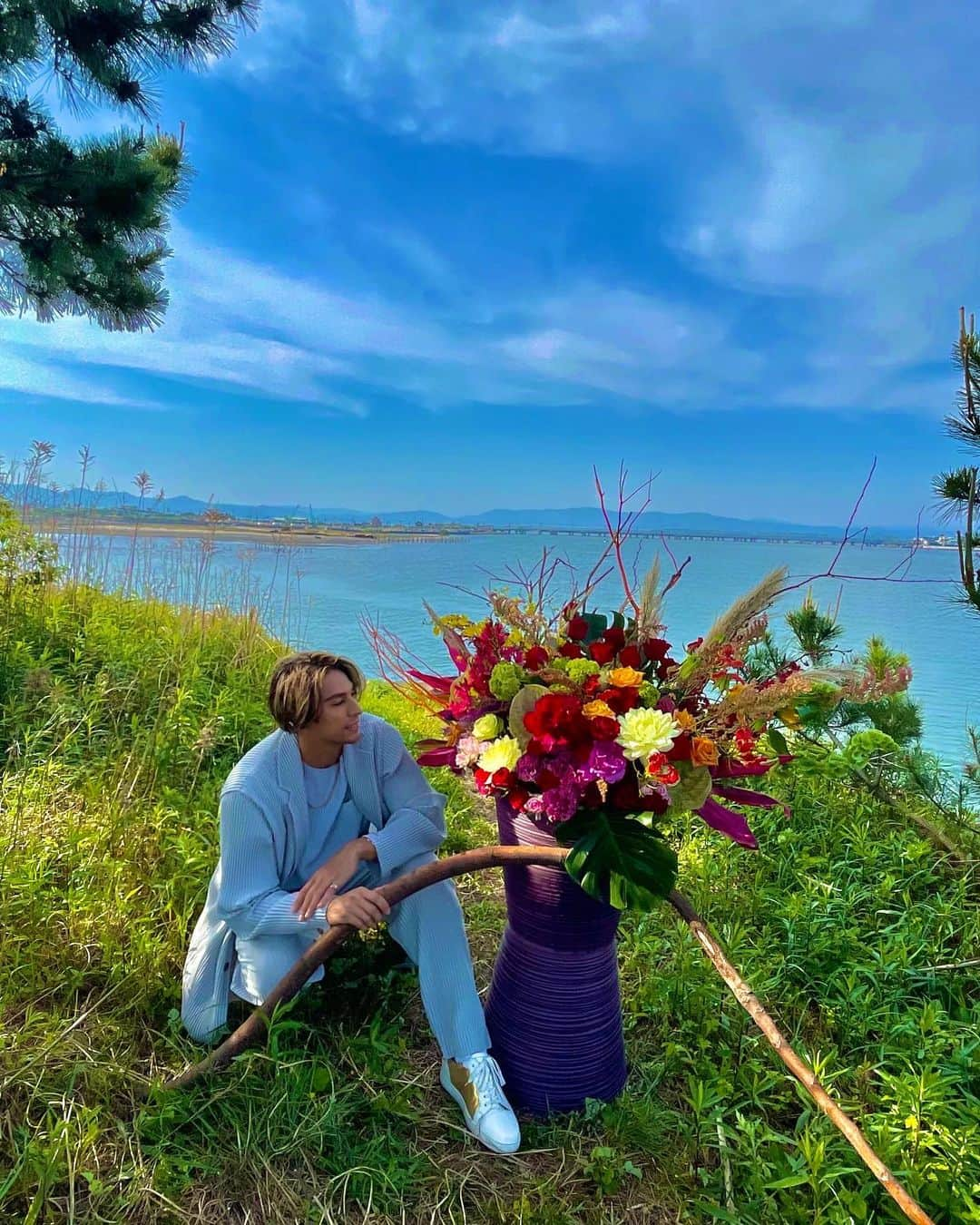 當間ローズのインスタグラム：「今回のGWの超大作💐  テーマは、”Beauty in the Nature“💐  浜名湖のほとりで生花、楽しかったし幸せすぎた〜🌹ここのロケーション最高！これからここを秘密基地にします😍  海、空、花と僕、これ以上何かいる？w  生けた後に、ここでお茶しました🫣  そして実は、実家の荒地に咲いてた野生花も積んで一緒に生けたんだ！どれか分かるかな〜？🙃  #生花 #flower #florist  #生花男子 #ラテンの貴公子 #ジム　#筋肉  #toumarose   #ラテン  #ハーフ  #モデル  #singer #Artist #Model #Tokyo  #Brazilian #brasil  #italian #fashion #fitness #muscle #body #sexy」