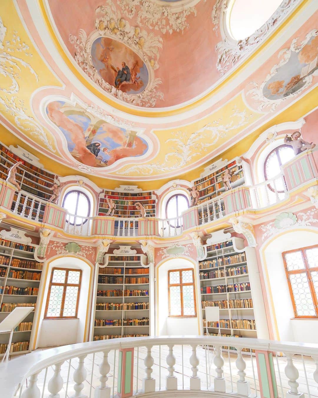田島知華のインスタグラム：「【Germany🇩🇪Fussen】 ドイツで訪れたパステルピンクの図書館。 ここはMuseum der Stadt Füssenの中にある図書館です。吹き抜けになっていて、晴れた日は窓から差し込む優しい光に包まれます✨ 色だけでなくロココ調の装飾がとっても素敵で、こんな図書館が近くにあったら毎日通いたい☺️ Copyright © TAJIHARU  PENTAX K-1 MarkⅡ  HD PENTAX-D FA 15-30mmF2.8ED SDM WR _ #たじはるトリップ #TAJIHARU_germany #ドイツ #バイエルン #フュッセン #女子旅 #旅ガール #カメラ女子 #visitbavaria #germany #bavaria #southgermany #füssen #fussen #museumderstadtfüssen #igerseurope #igersgermany #topeuropephoto #topgermanyphoto #visiteurope #visitgermany #bestgermanypics #wonderful_places #beautifuldestinations #beautifulplace #earthpix #discoverglobe #discoverearth #awesome_phototrip」