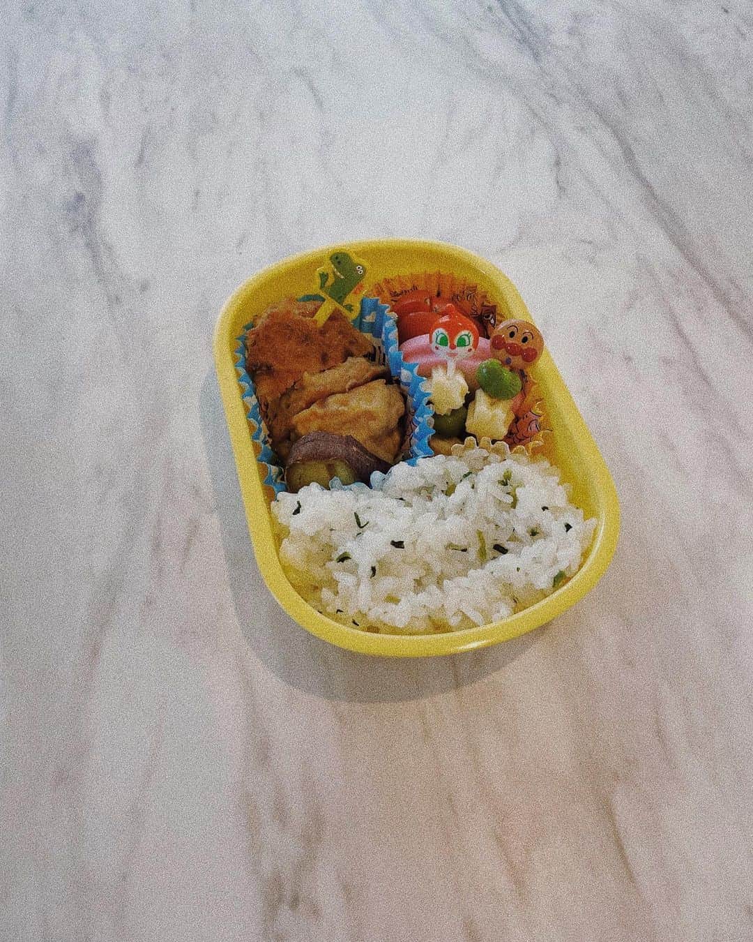 小屋春菜のインスタグラム：「今日私の人生で初めて作ったお弁当🫣 来週から娘の幼稚園でお弁当が始まるのですが、娘が1人で開閉できるお弁当箱、カトラリーケース、巾着。との事🍙 私もお弁当なんて旦那さんにも作った事無いからいきなり当日を迎えるのが不安で、、、お弁当箱の開閉が上手にできるかも兼ねて、作るところから娘が食べ終わるところまで予行演習。　昨日の残りの鶏つくね詰めただけで半分を占めてびっくり。あれもこれも入れてあげようと考えていたのに予想以上に入らないし縦列にしか置けない私の盛り付け力🥹　微妙な隙間を埋めてくれたサツマイモ、アンパンマンとドキンちゃんとレックスのお陰でなんとかそれっぽくはなった気がする。お弁当予想以上に難しそうだけど、娘が楽しそうに食べてくれて救われた〜🥹🫶🏼🫶🏼  冷凍食品使わずに、冷めても美味しい物を入れてあげたい！！！」