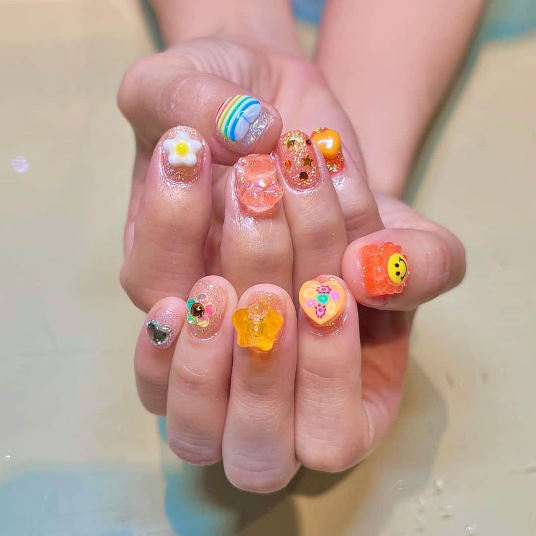 ぱいぱいでか美のインスタグラム：「🧡🍊🌞☁️🤍 . 久々にネイルいきました💅 先月が生誕終わってからネイル行く暇なく バタバタ仕事してたから仕方なくセルフでポリッシュ塗っていて🥲 ずっとLovl行きたくて禁断症状出てたからやっと行けてよかった。笑 2色のメンバーカラーを経験した大好きな推しメンをイメージして オレンジから白へのグラデーションと 白からオレンジへのグラデーションで 左右ともに小指から綺麗にベースのラメやってもらいました！ パーツはごりごりに乗せてもらえて最高〜 やっぱ爪はごりごりでありたいですね それからLovlさんのアニバーサリーのクッキー頂いた🍪 めっちゃ可愛くてそれも一緒に撮った🫶🏻 キャベツさんはじめネイリストさんみんなセンス良くて信頼しまくっております🫶🏻 . #nail #lovlnail #推しネイル」