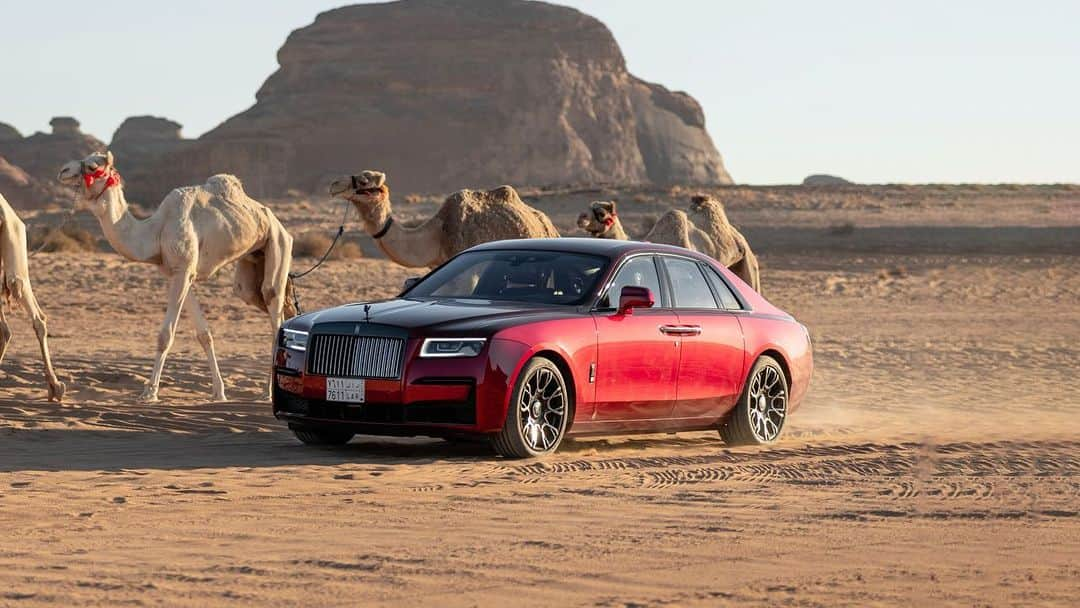 ロールス・ロイスのインスタグラム：「In this episode of the #SpiritofRollsRoyce, Mohammed and his Black Badge Ghost leave the urban metropolis for the distant wonders of AlUla, Saudi Arabia — a vast desert region brimming with cultural and natural heritage.   Astounding ruins and immense rock formations, such as Jabal AlFil or 'Elephant Rock', line its trajectory through the golden sand.   The motor car's fierce Magma Red finish evokes the searing heat of the Arabian sun. With unshakeable vigour and prowess, it advances on a journey of monumental discovery, encountering epic landmarks along the way.   Discover #BlackBadgeGhost; link in bio.  — NEDC (combined): WLTP (combined): CO2 emission: 359 g/km; Fuel consumption: 17.9 mpg / 15.8 l/100km. Further information: https://www.rolls-roycemotorcars.com/en_GB/information/fb-dat-wltp.html」