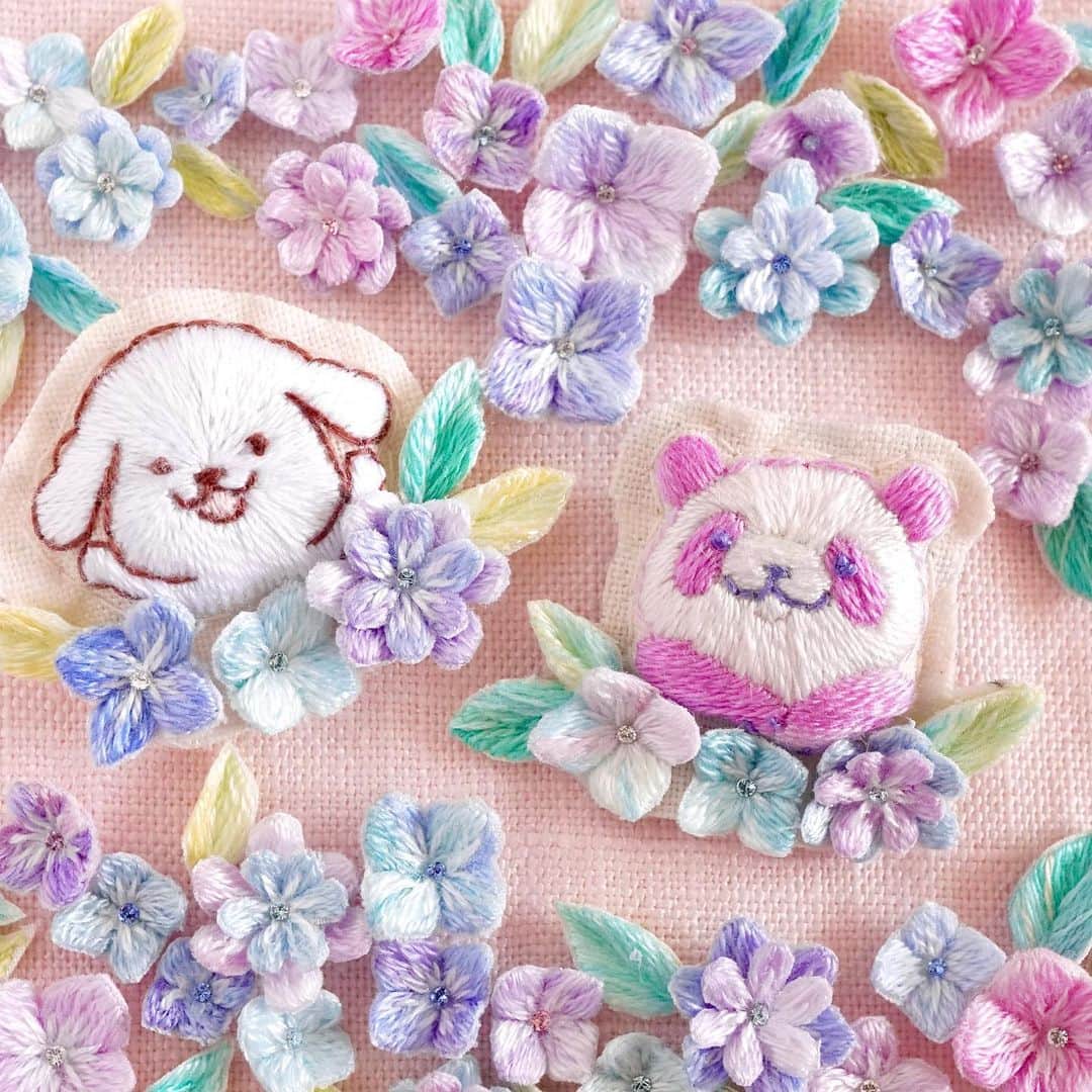 ダスキン ダス犬【公式】のインスタグラム：「【アートdeダス犬♪ハンドクラフト企画】 あじさいが見ごろの季節！ ということで今回のダス犬は  @moha._.mohaさんのパンダさんのコラボin刺繍のあじさい畑!  しかもしかも今回はダス犬初めての「立体刺繍」に挑戦!!  とってもかわいいブローチを作ってもらったよ♪   満開のあじさいに囲まれてなんだか嬉しそうなダス犬とパンダさんだね~◎  #あじさい #立体刺繍 #ダス犬 #パンダ  刺繍監修 @moha._.moha」
