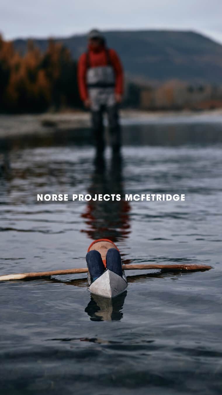 ジェフ・マクフェトリッジのインスタグラム：「PROJECT 24.06.2022 LOST ON A RIVER — NORSE PROJECTS X GEOFF MCFETRIDGE  “When I was a kid the short film Paddle to the Sea seemed to always be on TV. I grew up in St. Albert, Albert. A small town in Canada. It was the late 70s and we only had local TV. 2 channels over the air. No cable. It tells the story of a boy who carves a wooden figure in a canoe and places him on a river where he floats all the way to the sea. Along the way, the story of the canoe shows us the connectedness of our ecosystem and places the viewer in the middle of an adventure clearly determined by fate. It is well crafted but also feels like a collection of moments that just happened, but were captured on film.  Looking back I try to think of how things like Paddle to the Sea affected me. How what I saw or did as a kid affected my understanding of making things, loving the outdoors, art, and adventures.  Watching it in my Los Angeles studio I am transported to long boring days in my parent's basement. Underground on the leading edge of a frozen prairie. Snow pushed up against basement windows that barely let in the weak winter sun.  Forty years later I have a block of bass wood in a vice on my table. I chisel and carve at it to find a form. I shape the bottom to give my best impression of what a canoe looks like. The block of wood becomes a guy asleep in a canoe, two paddles at his side.  With some friends, I then fly to Montana. We pack food, camping and fishing gear into a raft and a canoe. Racing the coming winter we drive towards the Canadian border. The arranged shuttle driver has big hands like paws. He knows the area because he used to hunt bears there.  On a gravel shore, I kneel to slip my carved paddler into the Flathead River. We follow it. Paddling, sleeping on the ground, fishing, drawing, taking photos and filming for three days.  Seeing Paddle to the Sea as a child created an impression on me, and the project for Norse is in some ways an answer to that. To manifest an experience out of a memory, a feeling; is a type of art-making itself.”  Norse Projects x Geoff McFetridge Explore more via the link in bio #norseprojects #geoffmcfetridge」