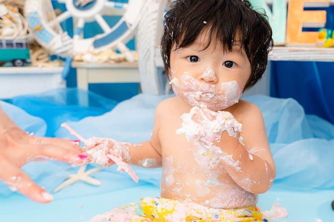 大本梨帆のインスタグラム：「6/21で湊心くん1歳になりました👶🏻💓 誕生日当日はLOVST みなとみらい店でスマッシュケーキの撮影をしました🎂 初めてのケーキにも動じず、開始5秒で1/4破壊するみなと🤣🤣 カメラマンの方にもたくさん褒められて上機嫌のみなと☺️💓 (後半は飽きちゃって泣いてたけどw) 手作りのリュックに一升餅を入れて自分より重い餅を背負って泣きながらも男気でハイハイするみなとを見てたら泣きそうになりました😢 産まれた時から今日まで大きな怪我や病気する事なく無事に育ってくれてありがとう☺️❤️ これからも大切にたくさんの愛情を注いで育てていきます🥰 ママ2年目もがんばるぞー❣️ みなくん誕生日おめでとう❤️❤️ #生後12ヶ月 ヶ月 #生後365日 #1歳誕生日 #バースデーフォト #スマッシュケーキ #lovst」