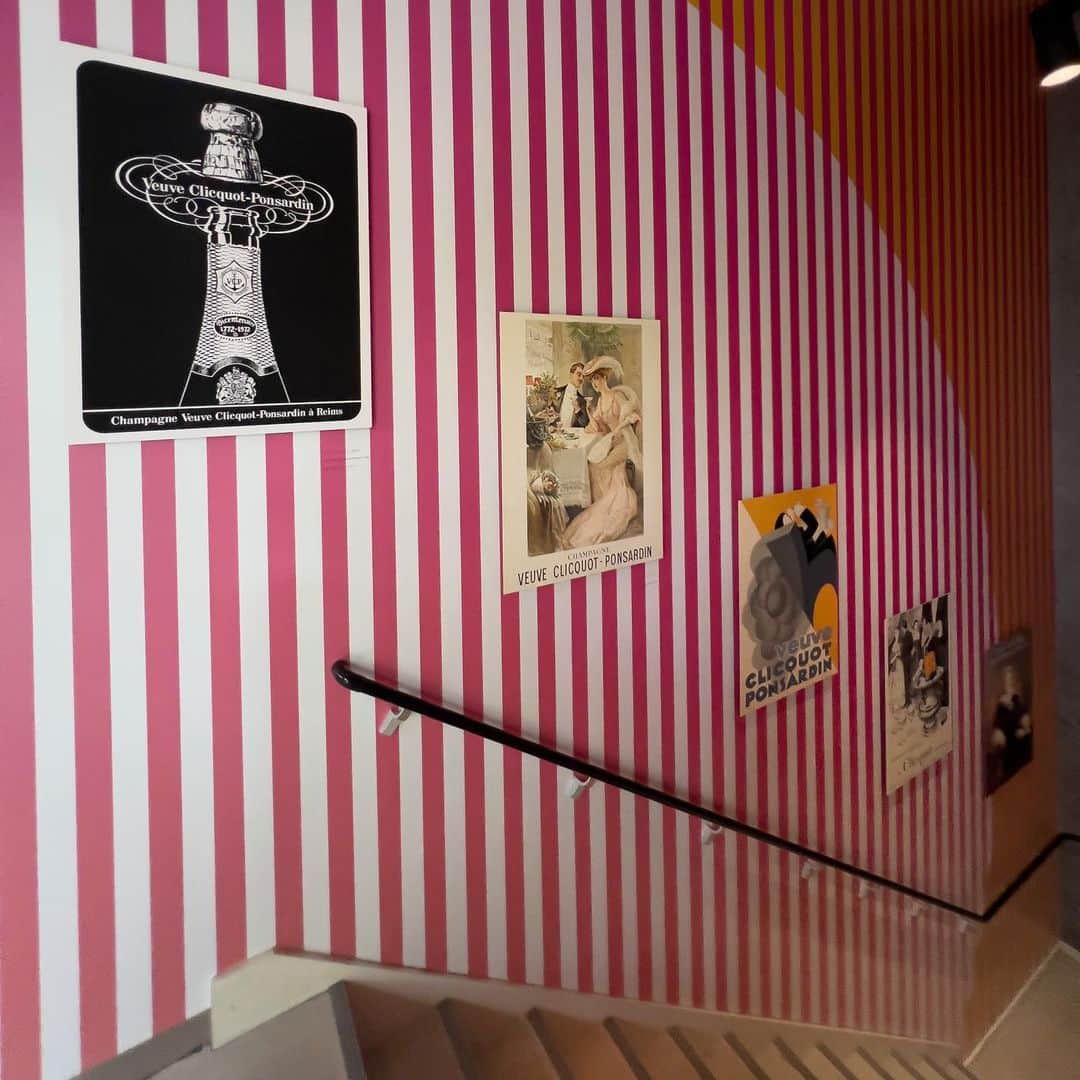 林信行さんのインスタグラム写真 - (林信行Instagram)「遊び心溢れるイベントや、世界的デザイナー、アーティストとコラボしたパッケージやインテリア… Veuve Cliquotは鮮烈なイエローのラベルに象徴される革新的なシャンパーニュメゾンだ。  その歴史とマダム・クリコのエスプリ、 そしてさまざまな創作が一堂に介した展覧会がまもなく終了する。  世界巡回企画展  Veuve Clicquot Solaire Culture（ヴーヴ・クリコ ソレール カルチャー）～太陽のように輝く250年の軌跡～ | VEUVE CLIQUOT -Sunday, 10 JULY, 2022 @ jing (Harajuku)  (check out the following comment for English summary).  La Grande Dame（ラ・グランダム）のシルクの味わいはもちろんだが、 アンドレ・プットマンやパブロ・レイソノ、カリム・ラシッド、トム・ディクソンと言ったクリエイターと組んで作ったコレクションしたくなる心くすぐるパッケージやインテリアなどVeuve Cliquotは、もっとも愛すべきシャンパーニュ・メゾンの一つと言えよう。 そのメゾンの創業250周年を祝う展覧会とあって、内容はかなり充実している。 現代アートの巨匠 草間彌生氏や、漫画家 安野モヨコ氏をはじめ世界各国から終結した１０名の女性クリエーターによる作品群を展示。特にメゾンが「現代美術のグランダム（偉大なる女性）」と讃える３名の女性アーティスト、シーラ・ヒックス、モニーク・フリードマン、タシタ・ディーンらは、この展覧会用に大型の作品を制作。 アートの展覧会としても十分楽しめるが、一緒にプーシキンやゴーゴリ、ジュール・ヴェルヌ、アガサ・クリスティ、そしてイアン・フレミングスなどVeuve Cliquotが登場する誰もが知る名作家の文学作品も展示されているのが面白く、「あの名作に登場していたのか！」という驚きがある。 一方で250周年を記念する作品として、メゾンの歴史にもしっかりと触れている。シャンパーニュの世界を常に革新してきた同メゾンの歴史を変えたメモや帳簿、宣伝用ポスター、さらには同シャンパーニュが振る舞われた歴史的イベントのメニューや古い機内食のメニューなど会場の至る所が見どころだらけだ。  個人的にはマダム・クリコが経営者としても、クリエイターとしても素晴らしい人物であることに本当に感銘を受けた。  ボトルを交換せずにワインから澱（おり）を取り除き生産性を向上させた「動瓶台」、ブレンド法によるロゼ・シャンパーニュ、５年間続いた不作という逆境から生み出した初のヴィンテージ（単一年のブドウだけで作った）シャンパーニュ、今ではシャンパーニュ地方の伝統ともなっている機能的かつ美しいシャンプノワーズ型のボトル、メゾンの鮮烈なアイデンティティーとなっている黄色いラベルなどマダム・クリコの発明やイノベーション。 女性が子育て以外の仕事を認められない時代、27歳の若さで引き継いだメゾンでどうしてこれだけの革新を起こせたのか興味は尽きない。 「品質はただ一つ、最高級だけ」など展覧会場に飾られているマダム・クリコの言葉も素晴らしい。 デザイン好きの人々には冒頭で挙げた４人のデザイナーによるクーラーやポーター、キャンプセット、チェアやデスクまで、遊び心溢れるインテリアの展示も、かなり楽しい。 そして、お酒が好きな人には最後の飲食スペースでLa Grande Dameを含むVeuve Cliquotの４つのラベルの飲み比べを楽しんだり、この展覧会用に用意された軽食のメニュー（ムニュ）でアペリティフを楽しんだりと、このまま常設してもらって何度でも足を運びたくなる大変素敵な展覧会だ。 シャンパーニュ好きはもちろん、アートラバーやデザイン好きの人、さらには女性リーダー達にも、是非とも終了前に足を運んでもらいたい展覧会だ。  #VEUVECLIQUOT #YayoiKusama #草間彌生 #AndréePutman #KarimRashid #PabloReinoso #TomDixon #安野モヨコ」7月6日 14時50分 - nobihaya