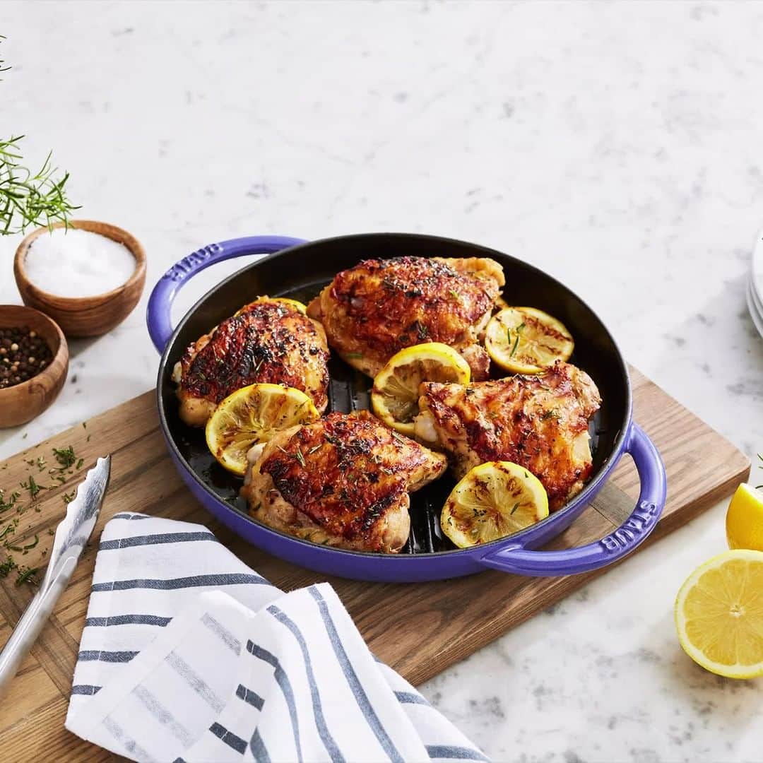 のインスタグラム：「Our new STAUB color, Blueberry, is now available exclusively at @surlatable! Celebrate the launch of this juicy color with this summery recipe courtesy of Sur La Table, and shop the color on their site. #madeinStaub  1 Tbsp minced garlic 1/2 tsp salt 1/4 tsp freshly ground black pepper 2 tsp minced fresh rosemary 1/4 tsp red pepper flakes 2 Tbsp fresh lemon juice 3 Tbsp extra-virgin olive oil 4 bone-in, skin-on chicken thighs, trimmed 2 large lemons, sliced into 1/4" rounds, seeded Vegetable oil  To a medium bowl, add garlic, salt, pepper, rosemary, pepper flakes, lemon juice, and olive oil; whisk to combine. Add chicken and toss to coat. Cover and refrigerate to marinate for at least 30 minutes or up to 2 hours.  Preheat oven to 450F. Preheat a grill or grill pan over medium-high heat. Remove chicken from marinade, pat dry with paper towels, season with salt and pepper, and place on grill, skin side down. Flatten chicken with a brick wrapped in aluminum foil or a grill weight. Cook until skin is crispy, about 8 minutes. Remove brick and turn chicken skin side up. Transfer chicken to a small, rimmed baking sheet and transfer to oven to finish cooking; an instant-read thermometer inserted in thickest part of chicken will register 165°F, about 15 minutes.  Wipe out grill pan, if using, and heat grill pan or grill over medium-high heat. Using a silicone brush, lightly brush lemon slices with vegetable oil and grill until grill marks develop, about 2 minutes per side.  Transfer chicken to a serving platter and serve with grilled lemon rounds.」