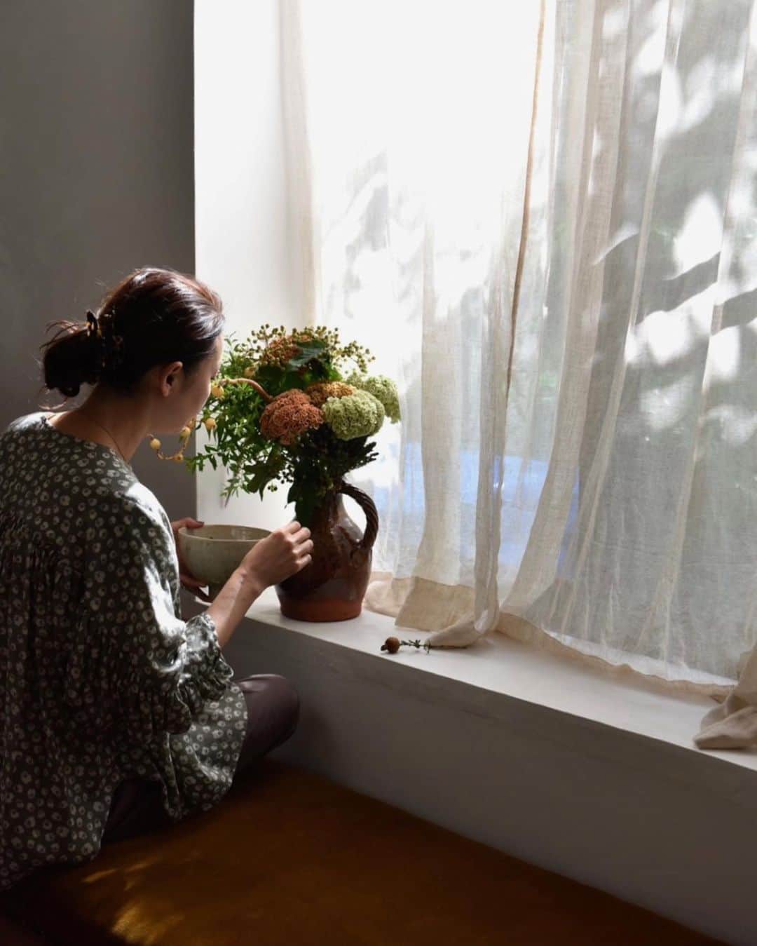 のインスタグラム：「夕暮れ時 ここ、夕陽が綺麗な一角。 世間はお盆休みで携帯も静か。 今日は一作業終えて、久しぶりにゆっくりな夕方、 部屋の片付けと番長タイム。  いつもね、私がメイクしようとすると、 出かけるのを直ぐ様察知して そわそわ落ちつきがなくなる番長。 自分の身体が思うように動かない上に、 置いてかれる不安で、どうしようもないみたい… ずっと傍にいてあげたいんだけどね。 大丈夫だよって、安心させてあげたいな。 なぜかだっこすると寝るのよね♡ 赤ちゃんみたい🍼  秋創刊の @masaki__personal_magazine_ 撮影で、 一足先に我が家にやってきた秋の花たちを 花器を選んでテキトーにアレンジしてみました。 こんなに暑いけれど、夜風が気持ちよくて 少しずつ季節がすすんでる気がする。 今宵はお月様がまんまるできれい！ まだ間に合うよ。 空見上げてみて🌕✨  明日のお昼久しぶりにインスタライブ やろうかと思ってます。 よかったら見てね。」