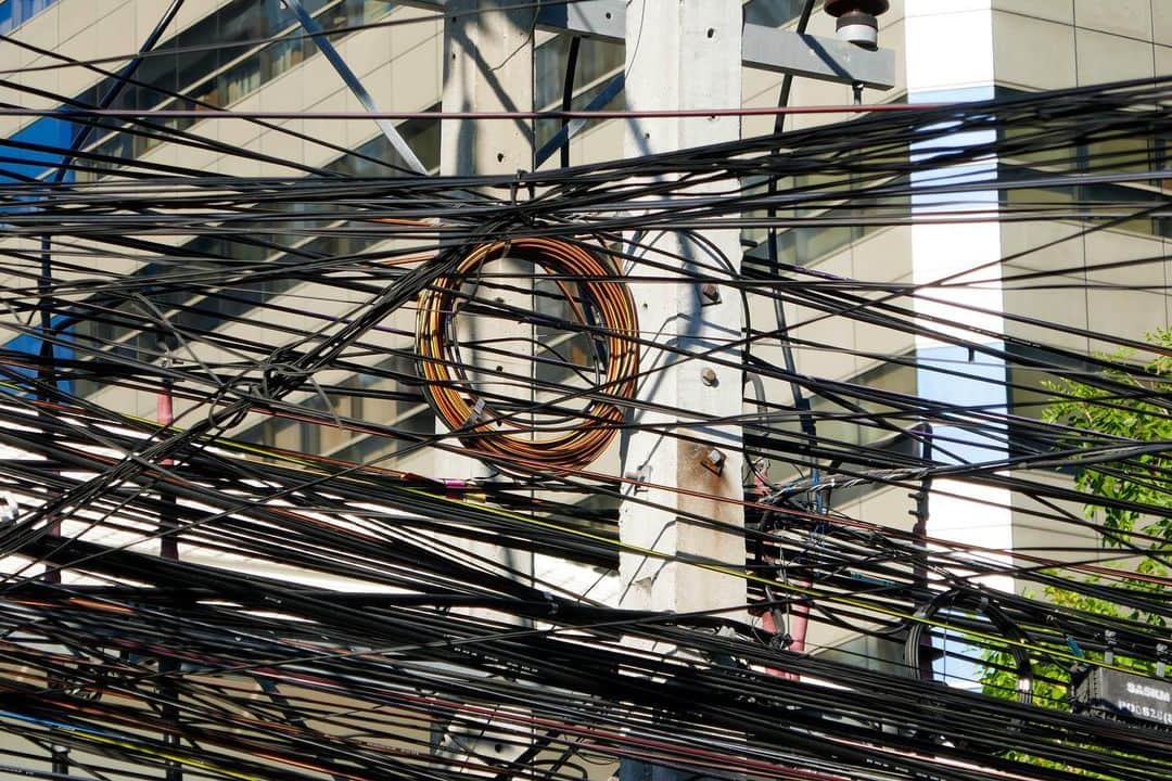 石山蓮華さんのインスタグラム写真 - (石山蓮華Instagram)「壁のような #いい電線 2020年1月のバンコクで撮りました。オレンジの南国がかわいい🧡 線を継ぎ足し継ぎ足し、秘伝のタレ化し、壁のようになった通信線➰  通信線の放置が社会問題化し、撤去工事が始まったそうです。 バンコクのチャチャート知事いわく「今後2年間で800㎞のケーブルを撤去する」とのこと。 #電線 #bangkokthailand」8月27日 11時42分 - renge_ge