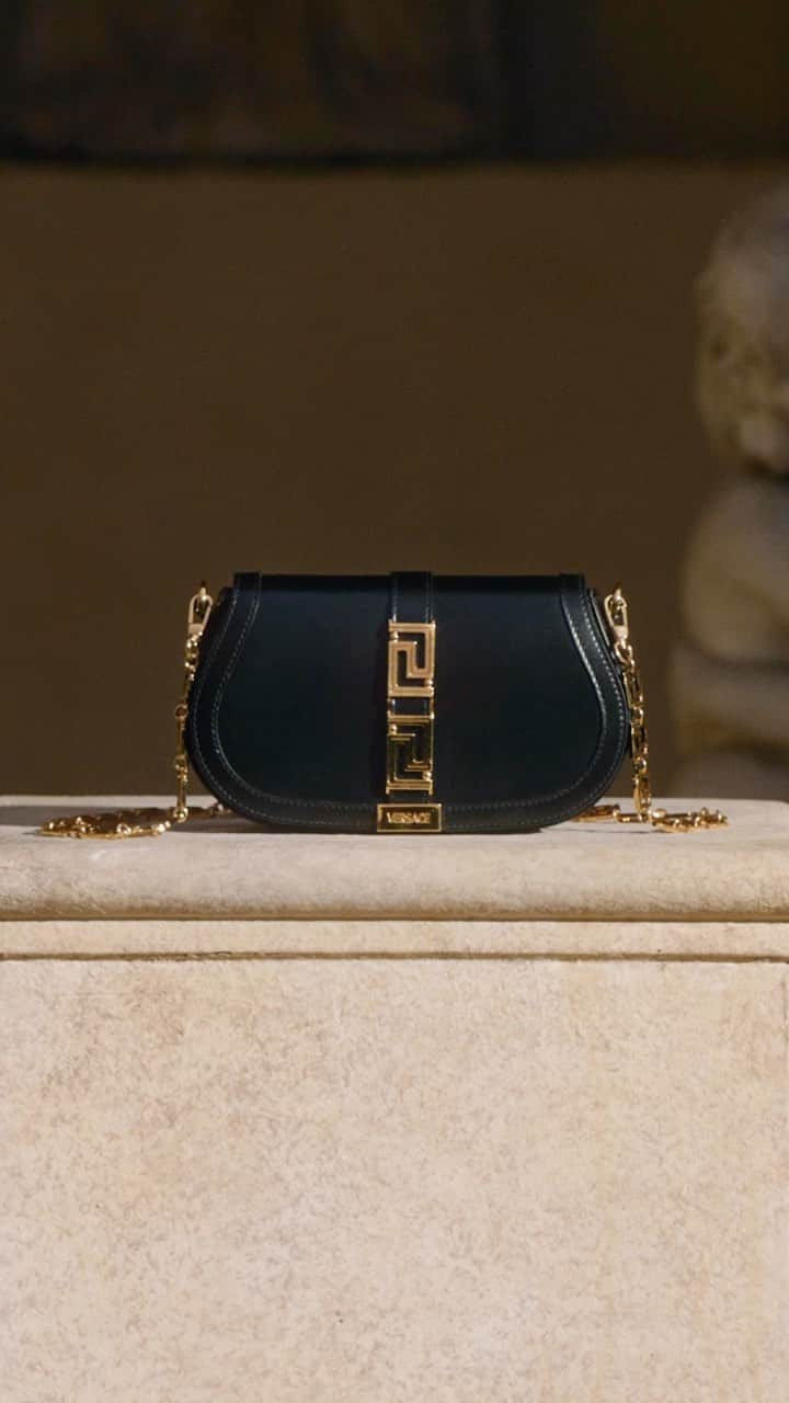 ジャンニヴェルサーチのインスタグラム：「Realize Your Inner Goddess.  The Greca Goddess bag is defined by the Greca insignia—a long-held symbol of the Versace brand that borders the Medusa head signifier and sits centrally to the new bag style.  #VersaceGrecaGoddess, now at Versace.com via the link in bio.  #VersaceFW22」