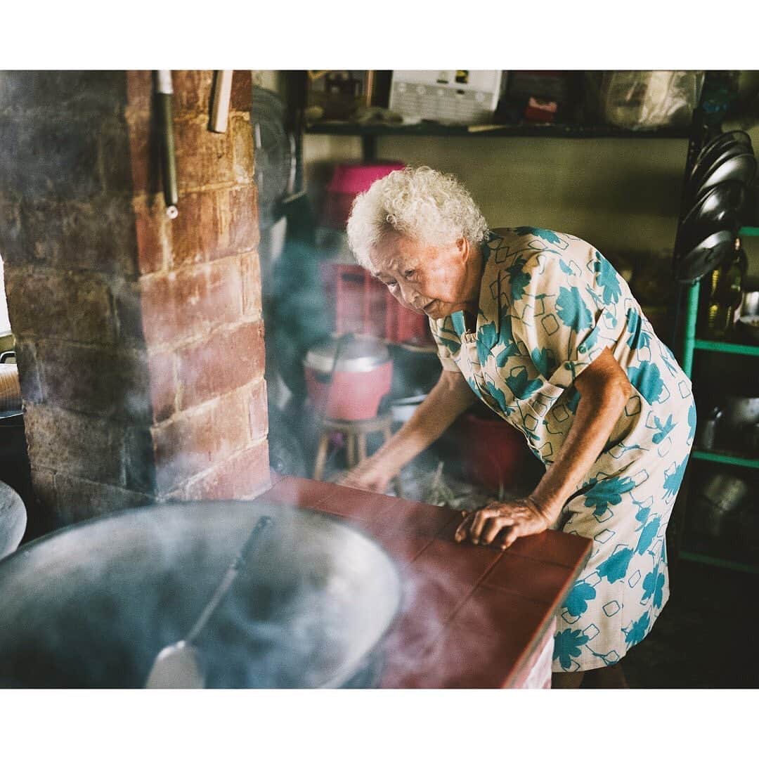 世界のKitchenから公式さんのインスタグラム写真 - (世界のKitchenから公式Instagram)「【台南のおばあちゃんがしてくれたこと】 ・ 本日9月19日は、敬老の日ですね。この日になると、台湾の取材で出会った、あるおばあちゃんのことを思い出します。 ・ 「思い出せないくらい昔からつくってるわ」 ごぼう漢方茶をこしらえながら、そう話してくれるのは、張さん。 ・ 一家が暮らすのは台南にある、素朴でやさしいペールトーンの伝統的なおうち。台湾では年長者が一番偉いとされており、四合院と呼ばれるコの字型の家屋の中でも、一番よい位置に部屋がある張さん。撮影ともなると、そこから一張羅にわざわざ着替えて出て来てくれました。 ・ まるでおうちとトーンを合わせたような、きれいな青い柄のワンピース！その愛らしい姿に、私たちの心もカラフルに染まります。 ・ 撮影後は外のお庭に出て、みんなでごはんをいただきます。おいしい、おいしいと食べる私たちのことを（本当においしかった）孫のように思ってくれたのでしょうか。帰り際になると、ぎゅっと手を握って、さすって、離してくれません。そして目尻には涙が。 ・ うれしさと、恥ずかしさと、あったかさと。ないまぜになった思いがくぅっと込み上げ、胸がいっぱいになったのでした。 ・ Photo by Yoko Takahashi ・ #世界のkitchenから  #世界のキッチンから  #世界の旅  #食と暮らし  #旅  #キッチン  #世界  #台湾  #Taiwan  #敬老の日  #料理  #レシピ  #recipe  #スープ  #ごぼう漢方茶  #手作り  #想い  #台所  #おいしい世界  #お家の時間  #家の時間  #高橋ヨーコ  #yokotakahashi」9月19日 20時02分 - sekai_kitchen