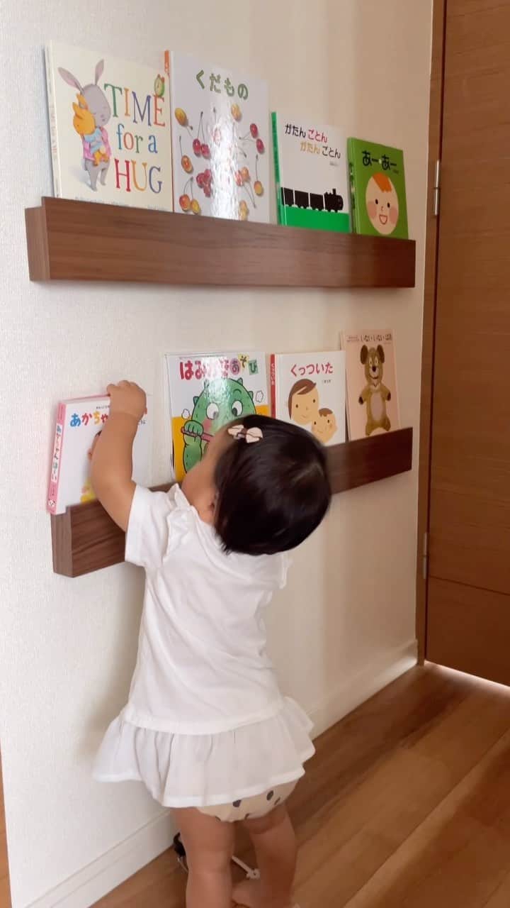 HISANAのインスタグラム：「リクエストの多かった絵本の収納👶🏻  絵本棚を作ったよ〜❣️ だいぶ前の楽天マラソンでゲットしたのに眠らせてました笑笑  ☑︎壁に付けられる家具長押 ウォールナット材突板 88cm 楽天roomに載せてます🏡  石膏ボードの壁なら簡単に取り付けられます👍 私ひとりで意外とさくっとできました！ トンカチみたいにゴンゴンしなくても、ペンチでぐーっとそんな力いらず押し込めました😆  可愛い絵本棚ずっと見てて買おうか悩んだけど、我が家はわんこがいるしおしっこかけられたりしたら悲しいので🤣 極力床に何も置きたくないひと🙋🏻‍♀️ 地面から棚を浮かせれてラッキーだし、デッドスペースの壁を有効に活用できて🙆‍♀️ 我が家はこれの3連ハンガータイプもバッグかけたりして大活躍してます🌟  我が家にはお兄ちゃんが小さかった頃の絵本も合わせると40冊あるんだけど、ここにない絵本たちは物置に収納してます📚 ちょこちょこ入れ替えようっと🤭  #生後10ヶ月#赤ちゃんのいる生活#赤ちゃんのいる暮らし#絵本棚#絵本のある暮らし#絵本育児#チャイルドコーチングアドバイザー#無印#無印良品#壁に付けられる家具#東京ママ#東京ママと繋がりたい」