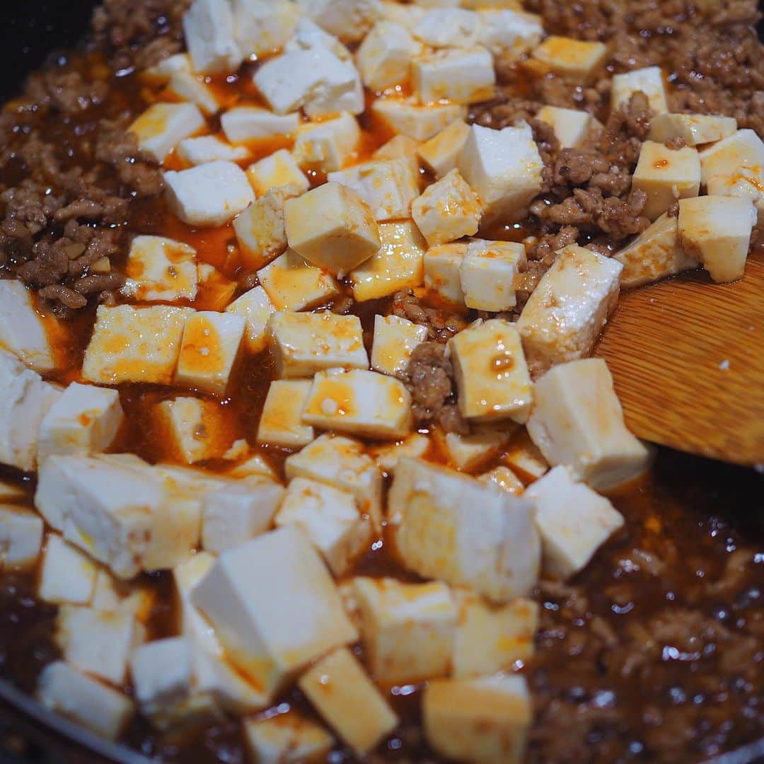シンプルご飯が好き。さんのインスタグラム写真 - (シンプルご飯が好き。Instagram)「ひき肉多めの麻婆豆腐。  子供が好きだから作るのに 味見しながら気づいたら大人味。なぜだろう…  一度覚えてしまうと結構簡単なんですよね。 手作り麻婆豆腐。  豆板醤は合わせ調味料にせず炒めると辛味も風味も増すのでお試しくださいませ。  簡単に作り方を。↓  【麻婆豆腐の作り方】  ひき肉300g 木綿豆腐　2丁 ネギ1本 生姜1かけ にんにく1かけ 豆板醤　好みの量 甜麺醤　大2ほど 鶏がらスープ　適当 醤油　　ちょろっと 水溶き片栗粉 胡麻油  生姜とニンニク、ねぎはだだーっとみじん切りにしておきます。ネギはあの切り方が良かです  胡麻油をちょっとだけ多めに入れたフライパンで生姜とニンニクを弱火で炒めたら、豚ひき肉をドンっと、ここ中火。 あらかた火が通ったらここで豆板醤さん。 じっくり炒めて香りと辛さを引き出します。  甜麺醤さんとしっかり味の鶏がらスープ(鶏がら粉末＋水で🙆‍♀️)をひき肉がひたひたになるくらい入れて煮立たせたら味見を。  薄ければ鶏がら粉末や醤油、濃ければ水、甘みとコクが足りなければ甜麺醤を適当に。  この麻婆豆腐で1番面倒なところですが 豆腐は合わせる前にさっと茹でておきます。 水分が抜け煮崩れしにくく、味もしみますので 面倒だけど、面倒なんだけど… 面倒だよね。  でも！  豆腐を入れたらもう9割は出来上がりです。  火を止めて1：1の割合でといた水溶き片栗粉を回し入れたら、焦げないていどにグッツグツに煮立たせながら木ベラなどをつかってよく混ぜます。  ここをしっかりする事でトロミがきちんとつきますので繊細な豆腐を傷つけないように丁寧に…かつ大胆に中強火で！  最後のネギは余熱で大丈夫🙆‍♀️  好みで山椒や花椒、辣油を入れて出来上がりです。  2回ほど作れば好みの味にきっとできる…はず。お試し下さいませ。  ＊寮生へ 明日はチョモランマカレーです。(しつこい)」10月5日 23時28分 - heavydrinker