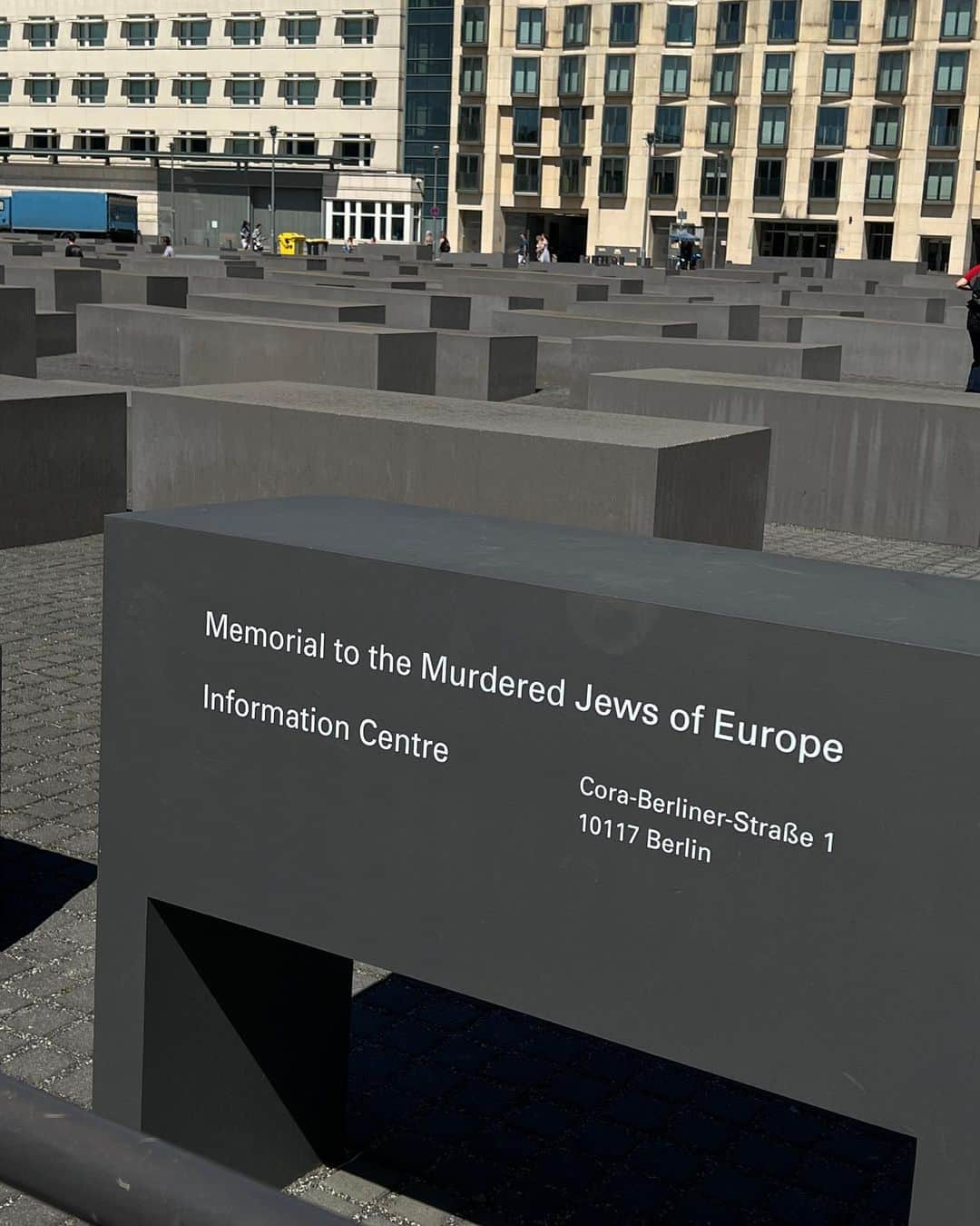 小柴綾香のインスタグラム：「📸2022.08.02  ブランデンブルク門のすぐ近くにあるMemorial to the Murdered Jews of Europeは、ホロコーストにより虐殺されたユダヤ人犠牲者に捧げる記念碑で、地下には資料館もある。 19,000㎡の敷地(サッカー場2面分)に、2711基のコンクリートブロックがマトリクス状に林立し、その間を人が歩く事ができる。  ベルリンの壁崩壊後の1994年にコンペ形式で、約500案の中から決まったというこの造形は、ニューヨーク在住の建築家・ピーター・アイゼンマンによるもの。石のブロックの隙間は1人しか歩けない幅で並び、どこまでも続く上に床面も歪んでいる。足を踏み入れると、たちまち終わりのない不安感に包まれる。 しかしそこを抜けると、人々がブロックの上に腰をかけてランチを楽しんだり、観光客がセルフィーを撮りまくったりしているから面白い。記念碑はベルリンの人々の生活の一部になっている。  これまで記念碑は、悲惨な歴史を継承しながらも、常に人々の議論の中心となってきた 。 例えば2017年には、アートプロジェクト「Yolocaust」によるアート作品(強制収容所の収容風景と記念碑ではしゃぐ観光客の投稿のコラージュ写真)が発表され、大きな話題となった。  社会に問い続ける記念碑の存在こそ、真のパブリックアートに感じる。  そもそも、ドイツの中心・ベルリンに、自国の歴史の暗部を象徴するパブリックアートを設置する当時の政府の姿勢も興味深い。そして現在それがベルリンのランドマークとして国民、観光客から愛されているのだから、 やはりアートのパワーは偉大だ。」