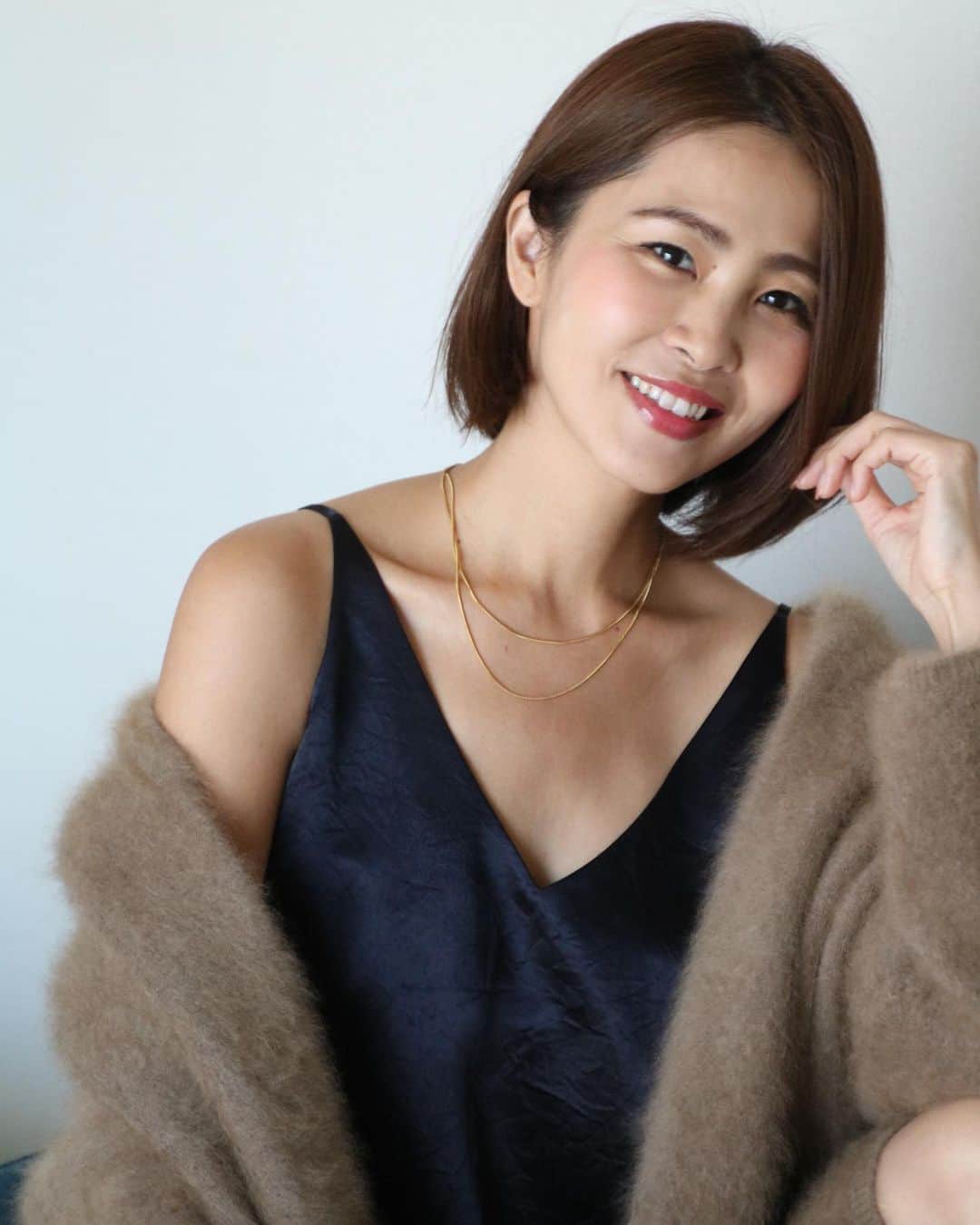 のインスタグラム：「おはよー  この前 この写真を投稿したときに 「お洋服はもしかしてNOBLEのですか？」 という質問を何件かいただいていたのですが そうです！正解です！！  このファーカーディガン、 私が着てるのは3年前に買ったものなのですが、 昨日ショップでチェックしてたら 今年バージョンのはドルマンスリーブぽくなってて もっと可愛くなってました🤍  中のネイビーのサテンのセットアップ （キャミとマーメイドスカート）は、 今秋のリアルバイです！  #noble」