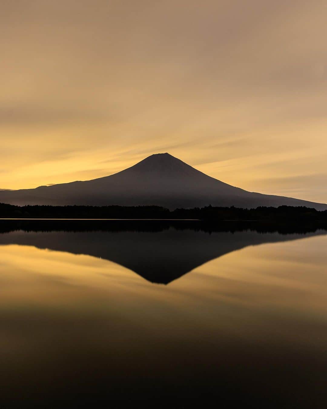 のインスタグラム：「日が沈み真っ暗な空の中、、富士山の裏から月が昇ってくると、たまにその月明かりが雲に反射して、俗にいう月焼けが起きるそう。  肉眼ではわからないけれど、 長秒で撮影すると、、 びっくりするくらい綺麗な黄金色に輝く富士山が姿を現してくれた✨ すごい！！  しかもダブル富士🙏 この上ないありがたいお姿。 これだから富士山撮影はやめられない。  #富士山 #ダブル富士 #富士山信仰 #黄金富士 #月焼け富士 #fujisan #mtfuji #fujiyama  #japantravel #japantrip #canon #canonR5 #beautifuldestinations #discoverjapan #discoverearth #voyaged #awesome_photographers #IamATraveler #wonderful_places #japanphoto #japanphotography #japan_of_insta #livingonearth #theglobewanderer」