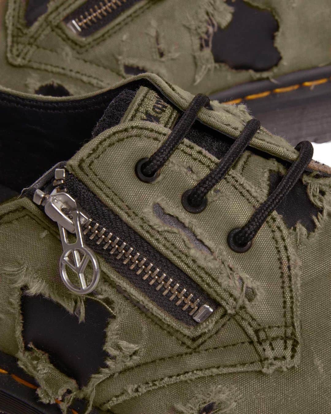 Babylon LAのインスタグラム：「The 1461 Babylon boot is built with a double-layer upper: a base of premium black Wanama leather covered with a tear-away olive canvas layer. Each shoe will scuff, mark, and eventually tear off entirely to reveal the contrasting base colour. The shoe is also detailed with badges on the heel counter and tongue showing DM’s and Babylon logos and an exterior zip in brushed silver with a Babylon LA logo puller. The sole reveals a CHAOS sole pad print and is secured with our signature yellow welt stitching.  ⚙️ @drmartensofficial」