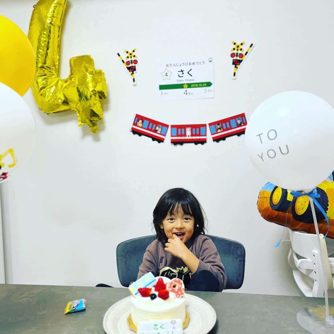 岡田優介のインスタグラム：「朔玖、4歳になりました。  ここ最近体調を崩していたので一月遅れの誕生日会。  1年前の投稿見て振り返ってみたのですが、朔玖が「出来ること」はぶっちゃけほぼ何も変わっていません。  かろうじて、(調子が良ければ)シャツの着脱が出来るようになったのと、靴下と靴を履けるようになったことくらいかなぁ。  ガッコウの先生からは、今日初めてコップを使ってスープを飲めましたと教えてもらいました。  相変わらず言葉は何も話せません。まぐれで出ていた「パパ」も最近消えちゃいました。(残念。)  朔玖は1歳半まではちゃんと1歳半児で、そこから今日までずっと2歳児くらいなイメージです。  まぁ身体は大きくなったのと、足も速くなったのと、力も強くなってるかな。あとはイタズラのレベルはなんか知らんけど上がっています。(怒られると分かっていることをわざとやる。)  朔玖の親として与えられた使命は、言われなきゃ気付かないくらいの些細な成長をちょっとずつ探すことです。  成長なのかブームが去っただけなのか分からない時もありますが。(あの謎のルーティン消えたよね、とか。)  幸いなことに周りの人たちに恵まれ、とても優しく接して頂いています。あと数年くらいは多少のことは「可愛い」で許してくれるボーナスステージかもしれません。  だんだん身体も大きくなって、子供だと見られなくなった時、更なる試練が待っていそうだなと、オヤジは身構えています。  なので図々しいながらも、今のうちは甘えちゃっています。(すいません。)いつも朔玖の相手をしてくださる皆さん、ありがとうございます。  これからもマイペースな成長を続ける息子を見守っていきます。  朔玖、誕生日おめでとう🎂  #4yearsold #自閉症 #自閉症あるある #写真撮影もおやつで釣らないと無理」