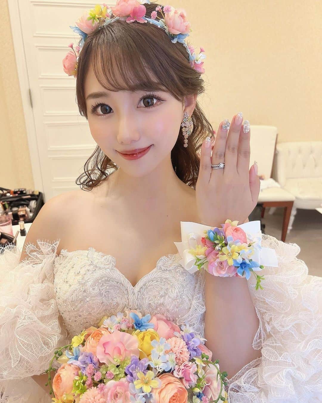のインスタグラム：「⋆  ⸜  披露宴𓏸撮影スタイル ⸝  dress𓈒𓏸 @thehany_official  bouquet𓈒𓏸 @anniversary214  accessories𓈒𓏸 @anniversary214  earrings𓈒𓏸 @thehanybijoux_official   披露宴、そして撮影の時は  THE HANY Celesteのドレスを袖ありにして 着用しました🤍 またイメージがガラッと変わって可愛いんです🥰 より華やかになりました🥹  そして、ブーケは @anniversary214 さんに お願いしました💓 色々とご縁があって、ブーケデザインのやりとり中も 本当に丁寧に対応していただいて とても嬉しかったです𓏧🥲❤︎ そして何と言ってもデザインが可愛すぎる𓏧！！💐🕊  カラフルなお花で華やかなドレスに負けないブーケを 作っていただきたかったのですが、 理想以上の大満足なブーケになりました😭🪞  そして、頭につけている花冠やブレスレット、 新郎の蝶ネクタイも合わせて仕上げていただきました🥺 これまた可愛い𓏧 是非スライドしてみていただけると嬉しいです🤍  こちらのブレスレットですが、 腕につけても可愛いし、スマホにつけることもできて、 自撮りする時などは付け替えて使うのがおすすめです🌷 鏡越しに撮る時もワンポイントになってかわいいよん💐  イヤリングは @thehanybijoux_official を合わせました❤︎ こちらもブーケのようなデザインになってて本当にお気に入りです💐❤︎  ⸜  新郎スタイル ⸝  tuxedo𓈒𓏸 @owariya.ordersuit  bow tie𓈒𓏸 @anniversary214  @ships_official  watch𓈒𓏸 @rolex  挙式、披露宴とタキシードを変えて、 ドレスの色味に合わせてみました♡ お花蝶ネクタイの写真はまた載せます〜⋈  #プレ花嫁 #花嫁 #沖縄婚 #リゾート婚 #ブーケ #結婚式  #ウェルカムスペース #東海プレ花嫁  #ウエディングドレス  #ウェディングドレス選び #thehany #2022冬婚 #2022秋婚 #披露宴 #披露宴会場コーディネート #卒花嫁 #プレ花嫁準備 #プレ花嫁さんと繋がりたい #プレ花嫁ダイエット #プレ花嫁2022 #ウェディング前撮り #ウェディング撮影 #ウェディングフォト  #沖縄挙式 #カラードレス #ラソールガーデンアリビラ #花嫁ヘアスタイル #ドレス迷子 #卒花嫁レポ #ゼクシィ」