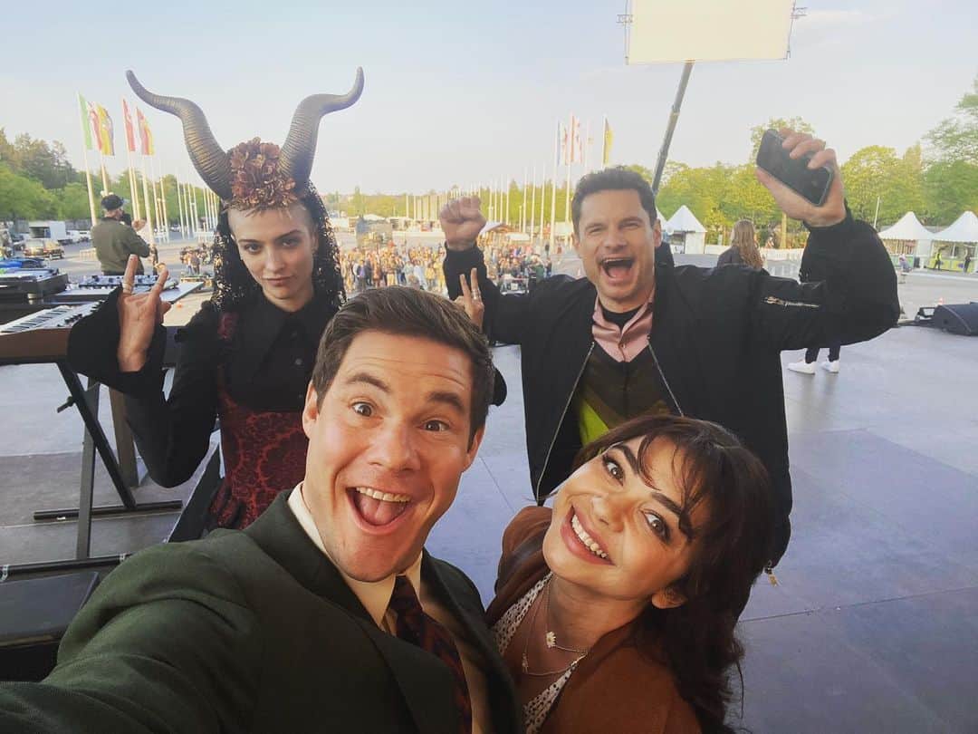 アダム・ディバインのインスタグラム：「Wow. What an absolute phenomenal response to Bumper In Berlin! Thank you so much to everyone who is watching and enjoying our weird little show. Thank you to @peacocktv for letting us do it ! Thanks to @elizabethbanks for birthing this weird lil baby and THANK YOU to our incredible showrunner @meganamram for teaching this baby how to walk and say it’s first words (pee pee- poo poo). The homies @straussschulson @richiekeen & @maureenbharoocha directed the show and made it infinitely more beautiful than a bumper spin off show has any right to be. Thank you to the incredible cast. You guys crushed beyond expectations and lastly, THANK YOU to the fans who gave this show a shot. So happy that I get to call this my job and it’s all because of you. Thanks a billion. 🍻」