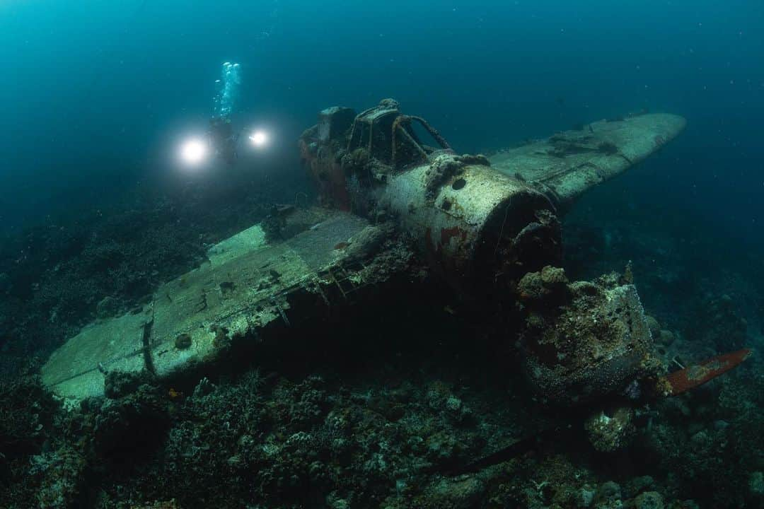 National Geographic Creativeのインスタグラム：「Photo by @shinalodon | On assignment for @insidenatgeo as second assistant for @kiliiiyuyan upcoming story about indigenous stewardship for @natgeo magazine  During our time working in Palau, we got to visit the wreck of a reconnaissance plane, Aichi E13A-1 (Allied reporting name: JAKE) of the Imperial Japanese Navy from the World War II. Here is Kiliii working around the plane that crashed in the shallow lagoon of Koror. Throughout those passing decades, marine life gradually flourish onto the plane that provides a substrate for them to grow onto. Corals and sponges encrust the eroded airframe, while reef fishes take shelter in the shadowy cockpit. Nowadays, Palau is world-renowned for its pristine marine environment and abundance of sharks that attract divers from all over the world, but the small nation of Micronesia was also a major battleground of the Pacific Theater, namely the Battle of Peleliu.  Kiliii is exploring traditional indigenous methods of conservation land-management and climate change mitigation as part of a new collaboration between the National Geographic Society and @TheClimatePledge The partnership supports National Geographic Explorers documenting the global climate crisis. So please follow @kiliiiyuyan for the update of his works mostly on indigenous cultures and @shinalodon for other stuffs mostly about marine conservation.  #plane #wreck #underwater #marine #nature #conservation #history #koror #palau #micronesia #pacific #onassignment」