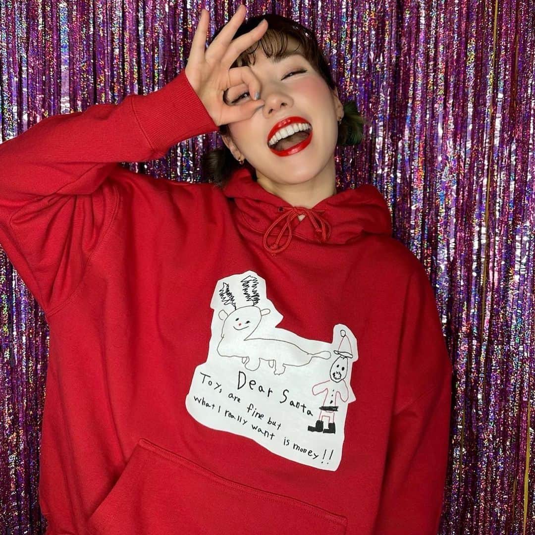 仲里依紗のインスタグラム：「本日12月19日の夜9時より🎄🎅🏻❣️ トカゲくんが1年ぶりに描きおろしてくれた可愛いクリスマスの絵をプリントしたクリスマスフーディーが発売になります💞🫶🏻  とってもチャーミングな絵とメッセージ🤣🎁💞🎄🦎サイコー🫶🏻❤️キツネさんも余裕で着れるBIGサイズだよ🦊  クリスマスフーディー購入してくださった全員に今年も仲里依紗サンタ🤶からギャル文字ランチバッグのプレゼントがフーディーと一緒に届くよ🎁♥️♥️♥️👛 ※色は選べません🙏🏻  こちらの商品を20日までに購入された方には 25日のクリスマスにお届けになります💋🎅🏻  @re._oyoufukuyasan_  さらに詳しくは👆に書いてありますっ🎄❣️✨」