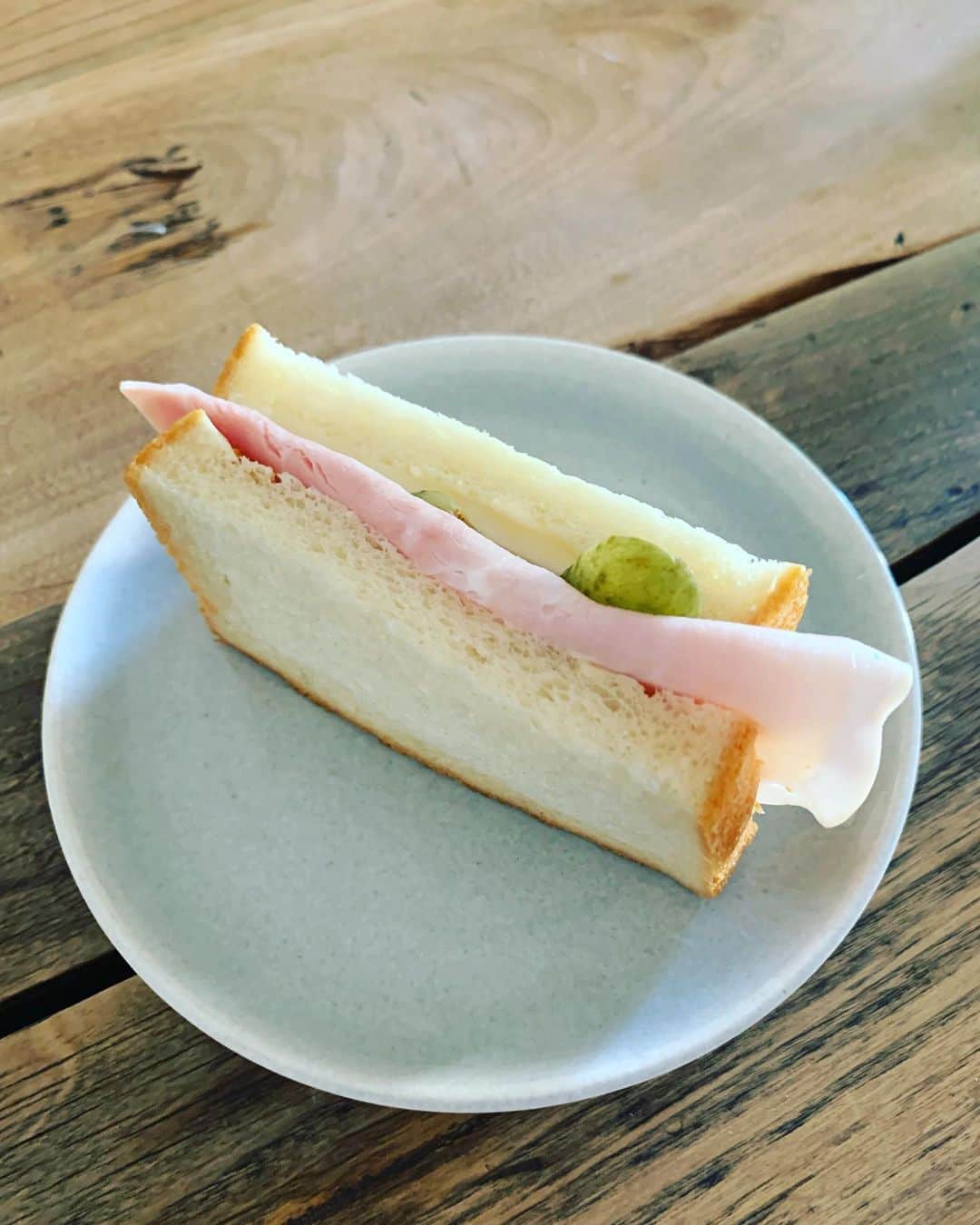 くらしのきほんのインスタグラム：「ある日の朝食。食パンに薄くバターを塗って、ハムとチーズ、ピクルスをはさんだサンドイッチ。大きめハムがポイント。あまりにかんたんですが、あまりにおいしいのでおすすめです。#くらしのきほん #松浦弥太郎 #サンドイッチ」
