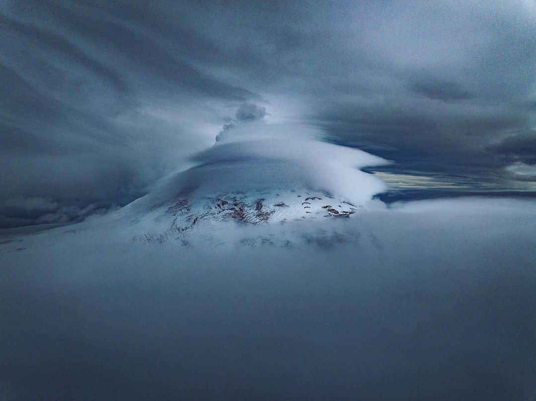 National Geographic Creativeのインスタグラム：「Photo by @renan_ozturk | A rare glimpse of the active volcano of Mt Micheal in the remote South Sandwich Islands and the target of our investigation of the @natgeo #LavaSandwich expedition.   On this drone flight, day one the island, I pushed up through what seemed like impenetrable fog to find this sliver of visibility.  Not only did we hope to make the first ascent of the volcano but also confirm the satellite anomaly that suggested w lava lake in the crater. This view wasn’t that promising!  Stay tuned…   @expedition.studios #onassignment」