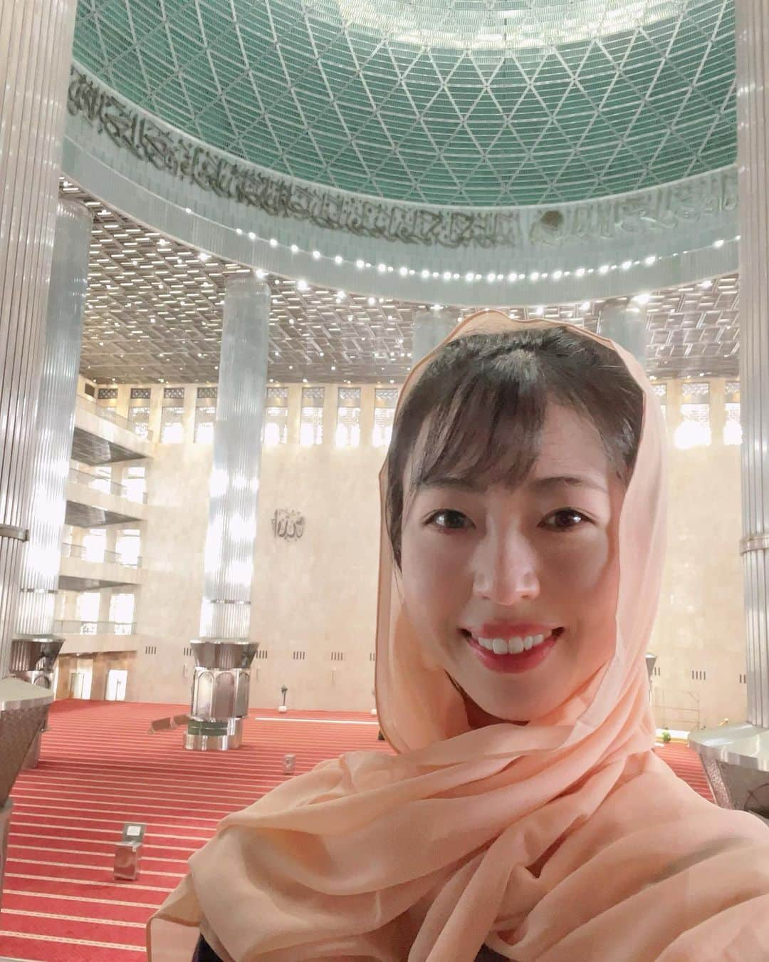 坂本奈津美のインスタグラム：「🕌イスティクラルモスク  ジャカルタ中心部にある東南アジア最大のモスク。  礼拝に訪れるムスリムだけでなく、観光客も中に入って見学することができます。  建物の外観は白を基調としたシンプルなデザインですが、中は異世界✨ 柔らかく外光が入る造りになっていて、開放的ながら荘厳な雰囲気が漂っていました。  この日はモスク主催の見学ツアーに参加。 受付のあとにジルバブをかしていただいて、初めて着用してみました🧕🏻 着てみたかったので嬉しい💓  ✏️大きな方のドームの直径は45m。この数字は1945年のインドネシア独立を意味している。  ✏️建物が5階建なのは、イスラムの5原則と、インドネシアのパンチャシラ(建国5原則)に由来している。  などなど、建物に込められた意味や歴史、モスクで行われている活動について、ガイドの方が詳しく説明してくださるので、興味深く見てまわることができました。  ツアーの最後にモスクへの寄付をするので、現金を崩しておくことと、靴下を持って行くのがおすすめです😊  #masjidistiqlal #mesjidistiqlal  #masjidistiqlaljakarta #istiqlal #masjid #assalamualaikum #イスティクラルモスク #ジャカルタ #ジャカルタ観光 #インドネシア #🧕🏻 #🇮🇩 #🕌」