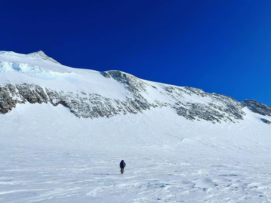 アレックス・オノルドのインスタグラム：「After hiking up Mt Vinson we decided to climb the neighboring peak to the north, Mt Shinn, which I think is the third highest peak in Antarctica. We went straight up the big snowy wall in the first photo and then climbed a nice rocky ridge above to the summit. But it was a bit more serious of climbing and a bit colder so I hardly took any pictures (it’s a pain to take off gloves to snap a pic on my phone… easier to just keep going uphill…).  There’s a photo of us on the summit, and the view looking north at the next few peaks (which look very impressive, and much more technical). And one random pic of @estebantopomena on the descent ridge, just because I was excited to see real rock.  Overall, I thought that Shinn was a much cooler summit than Vinson, with much more interesting climbing. It’s too bad that it’s not a little bit taller - it feels a little neglected as a 3rd tallest peak. Everyone’s there to climb the biggest one…」