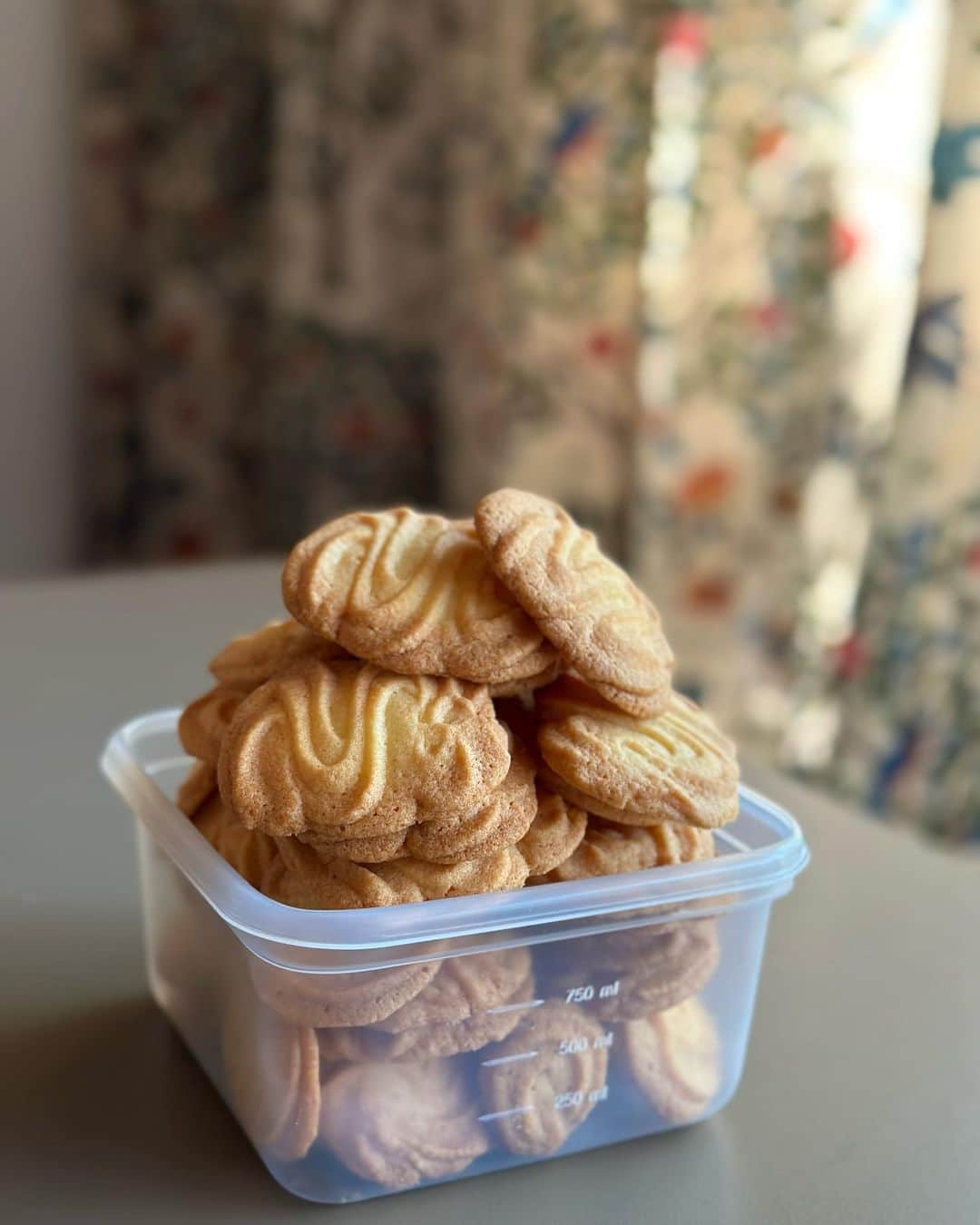 のインスタグラム：「山積みクッキー。「チャーム」っていう子供のころにお店にあった父のクッキーの再現にトライして失敗した山。  粉糖のクッキーとは違ってザクっとほろっとつながってないような食感で、焼き色はもっとしっかり、膨らみは低く、ふちはやや薄く、、、大きさはもう少し大きかったかな？　  焼き上がったクッキーを透明の袋に入れたら、ガッシャんて足で踏むヒートシーラで閉じて、シールを剥がして袋詰めのお手伝いをしてた。ガッシャん、ガッシャんとリズムカルにテンポ良くこなすのが出来ると嬉しかった。そして木の番重にぎっしり並べて。と、「チャーム」の味も時間も思い出は近づいてきたんだけど、再現は程遠くなんだか別物。美味しくないわけでもないんだけど。  父に聞いてみたら「あったね、（配合）残ってないな」と言うし、歳の離れた弟は「チャーム」の存在を知らないって。　@kobori1969   小学生の頃の記憶だから、今なら手のひらにのるサイズのクッキーが、両手で抱えて食べるくらい大きく感じてたのかも。　  少し前に実家に帰った時に、生まれ育った商店街を歩いてみた。裏の家の庭を通って、裏道の犬がいるところを怖いよーと言いながら通り抜けて、、、ようやく！着く思い出の場所は、迷路のような路地をくねくね、冒険！だったと思っていたのに、大人の足で２分とかからない場所だったなんてちょとびっくりだったし。  と、話はなんだかわからなくなってしまったけど、何度か配合変えて試作してみたけど、思い通りに出来上がらなかった「チャーム」。  思い出のあの味と、今食べても「おいしい」と感じられる私の「チャーム」をいつか作れるといいな。  ＊＊＊＊＊＊＊＊＊＊＊＊＊＊＊＊＊＊＊ 父が24歳で作った洋菓子店。子供の頃、窯もあって大きな作業台があると思っていた私の遊び場だった工場は、父のメモを見たら2坪しかなかった。お店も2坪だったよう。（2坪って4畳ないじゃん！間違えてる？！？）」
