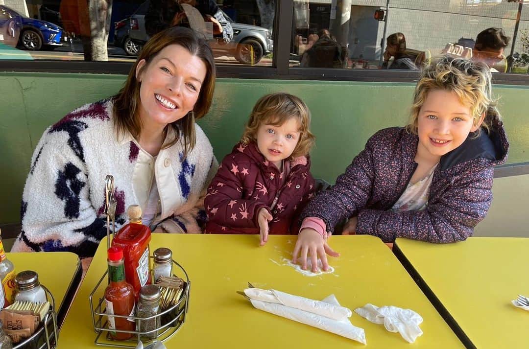 ミラ・ジョヴォヴィッチのインスタグラム：「Happy 3rd Birthday to my amazing littlest one Osian! It’s crazy how she suddenly turned 3 about a month ago. You know the feeling when they’re still toddlers and you can’t really have a conversation with them or reason with them? When they’re just little cave people who are either super happy, super angry, super selfish or super sad with no in between? And then almost overnight they become… little people? And the funny thing is, birthdays don’t really matter, it just happens regardless of when they were born. One day they just “get it”. Well one day about a month ago Osian suddenly began to display this wicked sense of humor. She started being “in on the joke” and with that I realized that my baby had become a full fledged little person who can have conversations and ask a million questions, seeing the world in her own unique, peculiar and truly hilarious way. She is my rainbow baby, my last and final human creation. And just as sweet, loving and spectacular as her two big sisters. We love you so much Osian Lark Elliot Jovovich-Anderson! May your life be as long, interesting and amazing as your name. And when you get married, add another hyphen to it, just because it would be as funny as you are. ❤️🥳🥳🥳 #longestbabynameever #happybirthdayosian」