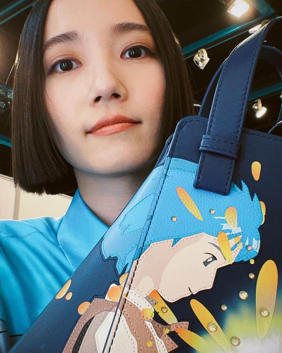大本彩乃のインスタグラム：「美容室で、まさにこのバッグの少年ハウルのシーン画像を見せて「あの、こんな感じの分厚い襟足にしてください」と、お願いした髪型でした💇  バッグのハウルとお写真撮れちゃって嬉しい。  チャーム類も可愛かったです〜  ロエベ×スタジオジブリ 『ハウルの動く城』カプセルコレクション   @loewe #LOEWE #ハウルの動く城 #ロエベとハウル#prfm @prfm_official」