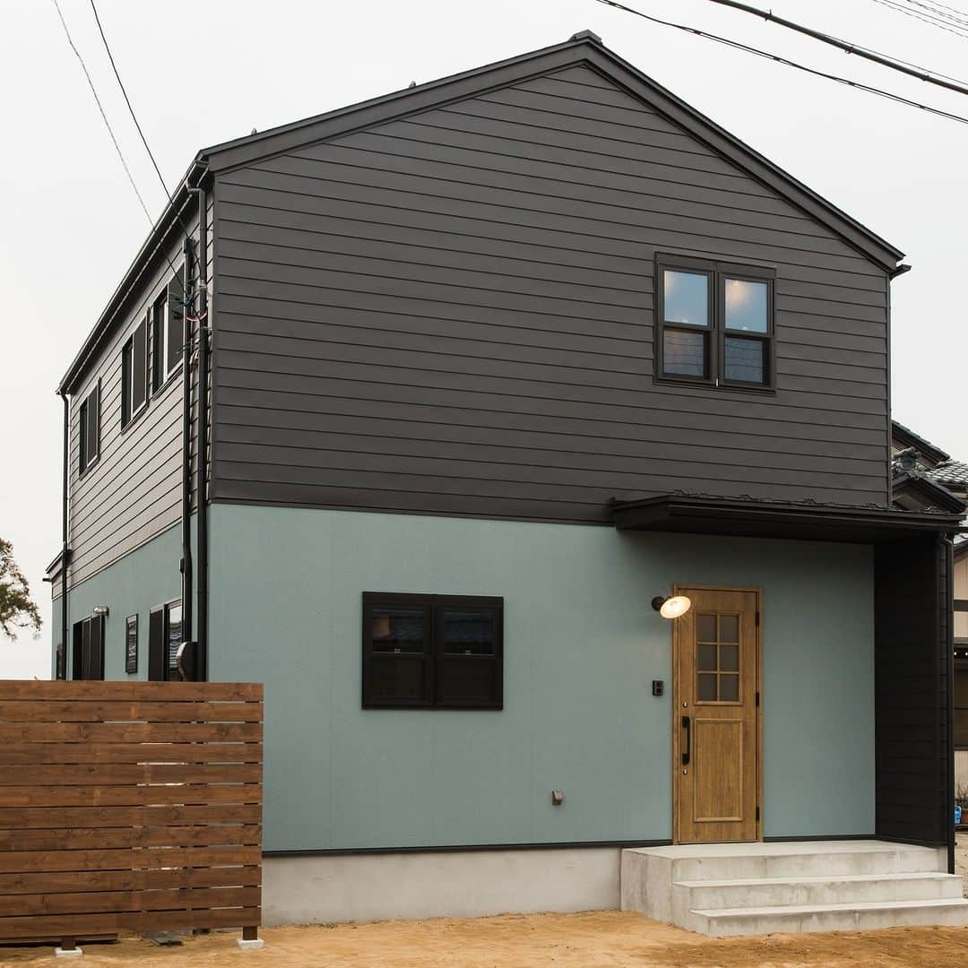 デフィニットハウスのインスタグラム：「▲⁑◇▲⁑◇▲⁑◇▲⁑◇ 【施工実例】外観 TWO TONE HOUSE  ⌂  シンプルで親しみがある 三角屋根のお家。 . . 2階部分はブラックのガルバリウム 1階部分は無機質な雰囲気をまとった ブルーグレーの塗装で仕上げました。 . . 奥様がセレクトしたカラーと 土間の玄関、傘付きの照明 可愛いカフェのようなお家が 出来ました☕  ▲家は楽しみ!!でできている。 プランニング・概算お見積りは無料です。 ご相談も無料ですので、 お気軽にお問い合わせ下さい。  ーーーーーーーーーーーーーーーーーーーーーーーーー #福井工務店#福井住宅#福井市住宅#福井新築#福井マイホーム#注文住宅#福井新築#福井新築一戸建て#福井家づくり#福井リフォーム#福井リノベ#デフィニットハウス#無垢材#無垢フロア#無垢ドア#無垢の家#三角屋根#ツートーン#ガルバリウム#塗り壁」