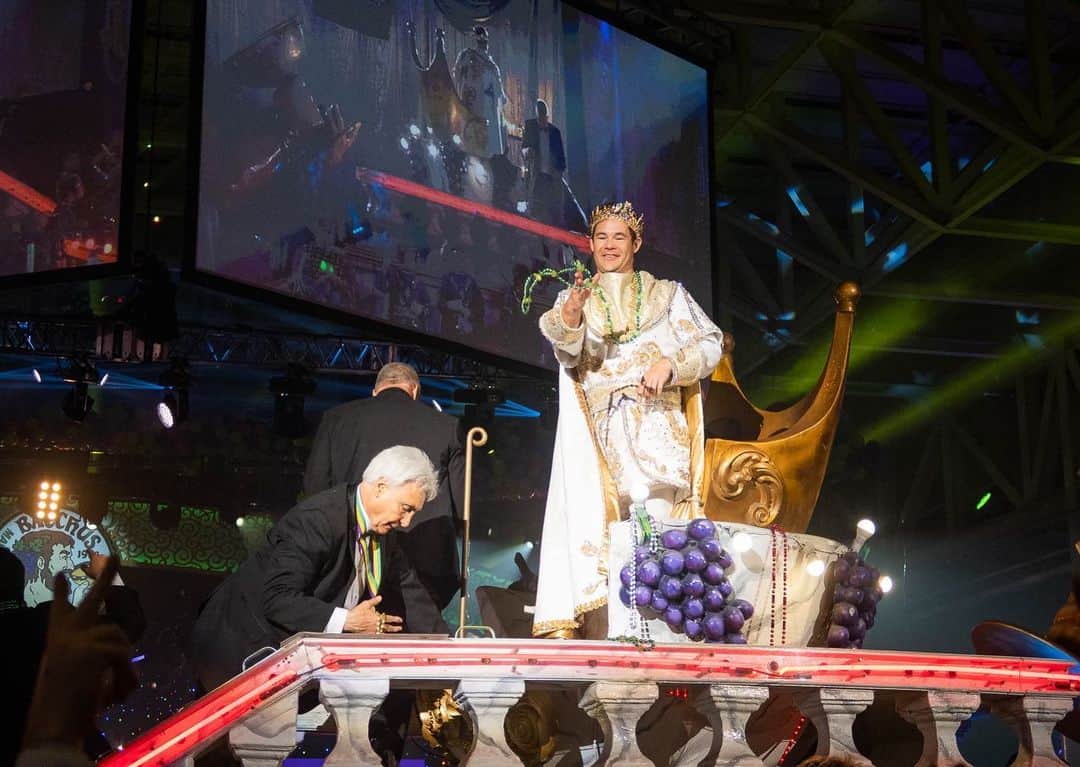 アダム・ディバインのインスタグラム：「So this past Sunday I was the King of Bacchus! One of the biggest Mardi Gras parades in New Orleans! It was an incredible honor and maybe one of the coolest experiences of my life. Thank you to John and Anna Beth Goodman, The Brennan family, George Grimes and everyone who made this unbelievable experience happen for myself, my family, and friends. Hail Bacchus!!! 🙌  1) as this King I had rain down plastic beads for the people! Sorry if I hit you in the face but hey it’s Mardi Gras baby! 2) My family came out to support and we partied all night in a convention hall with 9500 of our new best friends. God I love New Orleans.  3) Blake was there and we went hard. As we do.  4) All the homies got to ride on the float directly behind me and shower the people with jewels (plastic beads).  5) Had to take a shot with the best bud @atibaphoto before strapping myself in for the 4 hours of parading.  6) A past king was there! @anthonymackie. He gave me advice on being a good king. (Throw tons of beads).  7) practicing the previous Kings advice.  8) @chloebridges the Yas Queen and her court partied (took tons of photos) as we paraded.  9) Took time to thank the military before getting on the float. It ‘‘twas the Nobel thing to do! 10) The King and his Court. Some old and some less old. Damn did we have a good time!」