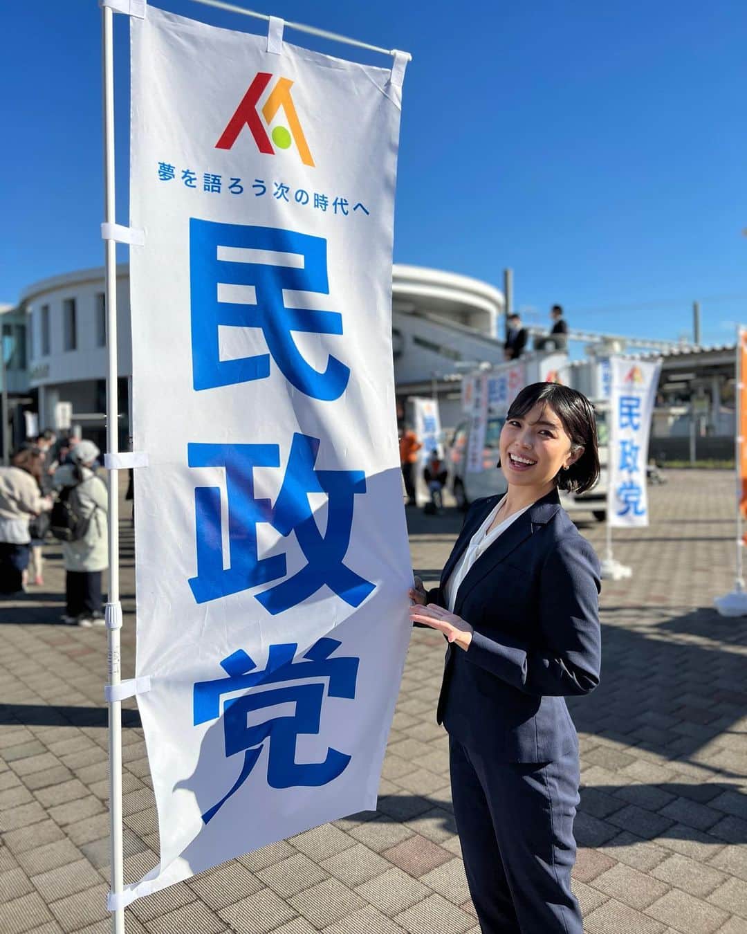 新原ミナミのインスタグラム：「今週も罠の戦争ご視聴の皆様、ありがとうございました！新原もリアタイできました📺 泰生くんの病状、罠の掛け合い、熱い演説、そして当選、次回予告。全てにワナワナ🥹  鴨井大臣と共に、小鳩も鷲津さんの演説の場におりました〜！撮影日はほんっっとに快晴で、何か不思議な力を感じるくらい雲ひとつない青空でした🌞そして、本当に胸が熱くなる演説でした🐦 民政党の旗と、そして鴨井大臣のパネルと📸  今週の鴨井大臣の赤いスーツもとっても素敵、、、 まだご覧になってない皆様、TVerなどの配信サイトでご覧になれますので、ぜひぜひチェックしてみて下さいね🐦」