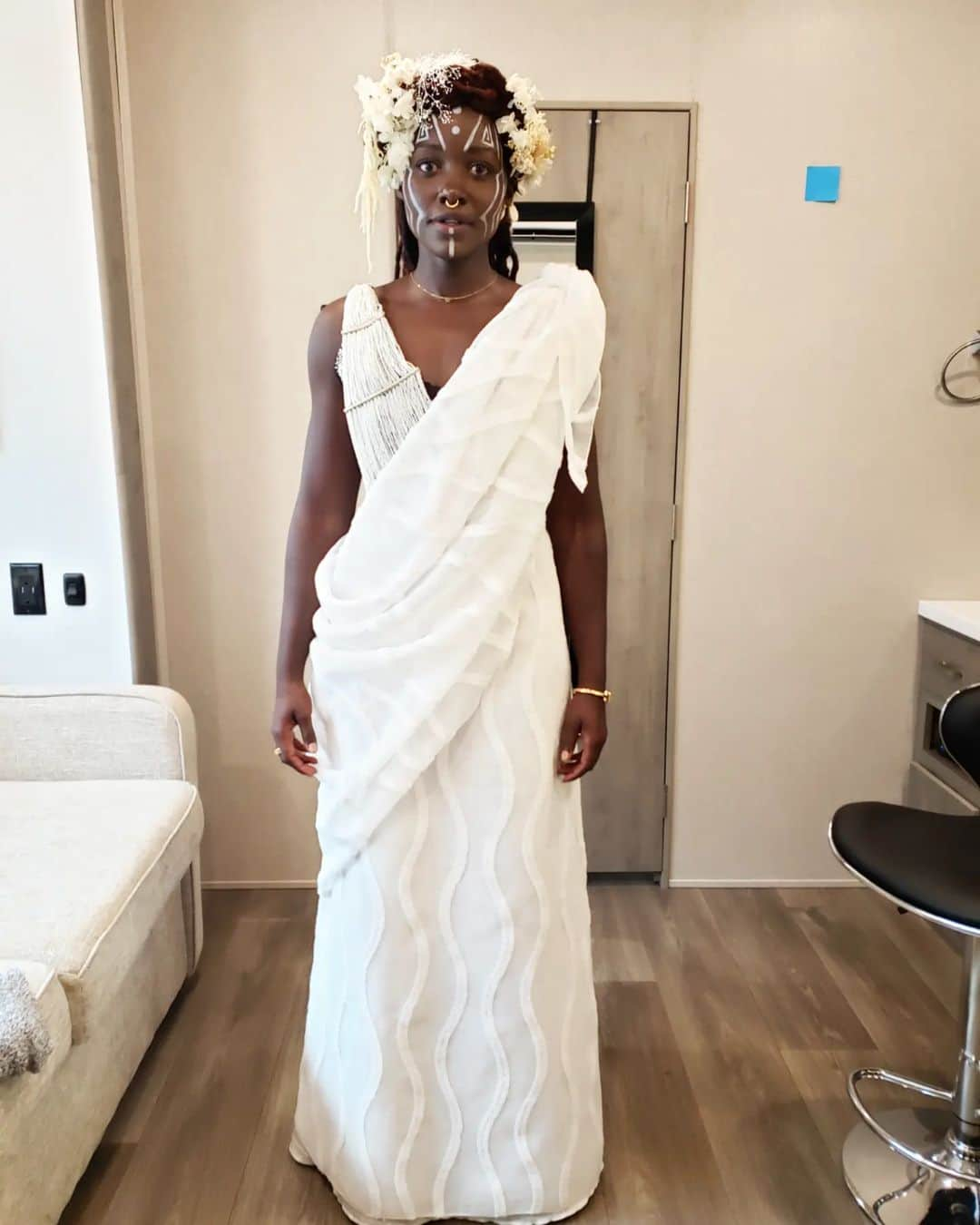 ルピタ・ニョンゴのインスタグラム：「Celebrating @therealruthecarter, #BlackPanther #WakandaForever costume designer(swipe ↔️ for context).  Ruth is all about collaboration and cultural appreciation and here is an example: : When I went into my first fitting for #WakandaForever, Ruth was still trying to figure out Nakia's look for Ramonda's funeral. She shared some concept art with me and wanted to hear my thoughts and ideas. I had been in Kenya earlier that year, and my sister Fiona had attended a friend's Rwandan wedding in full Rwandese regalia. I was blown away by how elegant she looked, how gracefully her clothing flowed. I shared the photo with Ruth and she loved it too. So, just like that, it became the basis of inspiration for Nakia's look and this is the final result. Ruth took it and RAN a MARATHON with it! : It is one of my favorite costumes of all time. The full look did not make an appearance in the movie (you only see a close-up of my face with the incredible head piece and face paint inspired by the Omo tribe of Ethiopia) so enjoy it with me here. : And let's give Ruth all her flowers, for highlighting, preserving, elevating and inspiring afro-historic and afro-futuristic style! Congratulations on the well-deserved #Oscars win for Best Costume in a Motion Picture.」