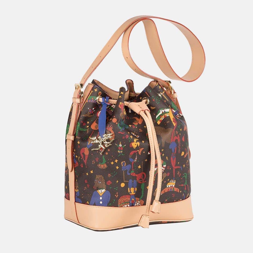 ピエログイディのインスタグラム：「Collezione Magic Circus “la Fantasia non muore mai” – presentiamo la borsa a secchiello mod. “Sofia”. Realizzata con lavorazione a “selleria”, in cuoio pregiato e tessuto goffrato stampato in 13 colori con il disegno di un circo magico.   #PieroGuidi #MagicCircus #Pgcreativefactory #loveitaly」