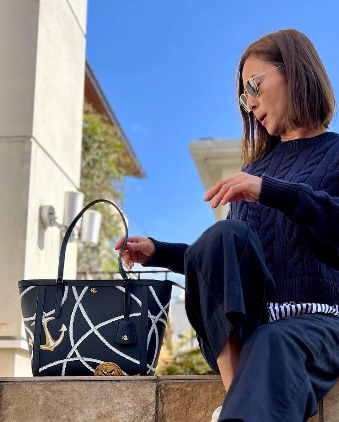 HARUKO（真木明子）のインスタグラム：「レザートートバッグ  ネイビー大好き人としては、 まずネイビーの素敵なバッグを見つけるのが難しいのです。  そして、さらにネイビーのレザーのバッグを見つけるのは さらに難しいのです。 そして、ネイビー一色ならまだしも レザーにプリントされた素敵なバッグを見つけるのは もっともっと難しい。  だからこのバッグは ネイビー好きにはたまらない魅力が詰まっています。  ローレンラルフローレンらしい柄。  コンセプトの「ヨットクラブ」からインスパイアされた ロープとイカリのプリント。 持っているだけで海を感じさせ、洗練されたプリント柄は フロリダのパームビーチにいる姿が目に浮かび妄想が膨らみます。  クロスハッチレザーで細かいスジ状の型押し加工してあり そこに、傷がつきにくいコーティングが更に施されているのでお手入れも楽です。  大きすぎず、小さすぎず日常使いにちょうど良い大きさ。 マチが広いので収納力もありますし 中にオープンポケット❌２、ファスナーポケット❌１ 外にオープンポケット❌１あり 上蓋はジップアップ開閉式で中身が見えません！落ちません！  自立型で底に鋲が付いているので 気軽に床に置くことができる。  持ち手が長いため、肩にかけて使用しやすい。  シンプルな服にこそ映える ネイビーレザートートバッグ  デニムにTシャツでも スウェットにこのバッグでも おしゃれな感じです❤️  ネイビー❌ホワイトの 上品で、トラディショナル、タイムレス、エレガント、マリンなテイストがお好きな方  是非是非QVCでお買い求め下さい❤️❤️❤️  3月10日10時から放送 #qvcジャパン  #laurenralphlauren   QVC先行販売！！」