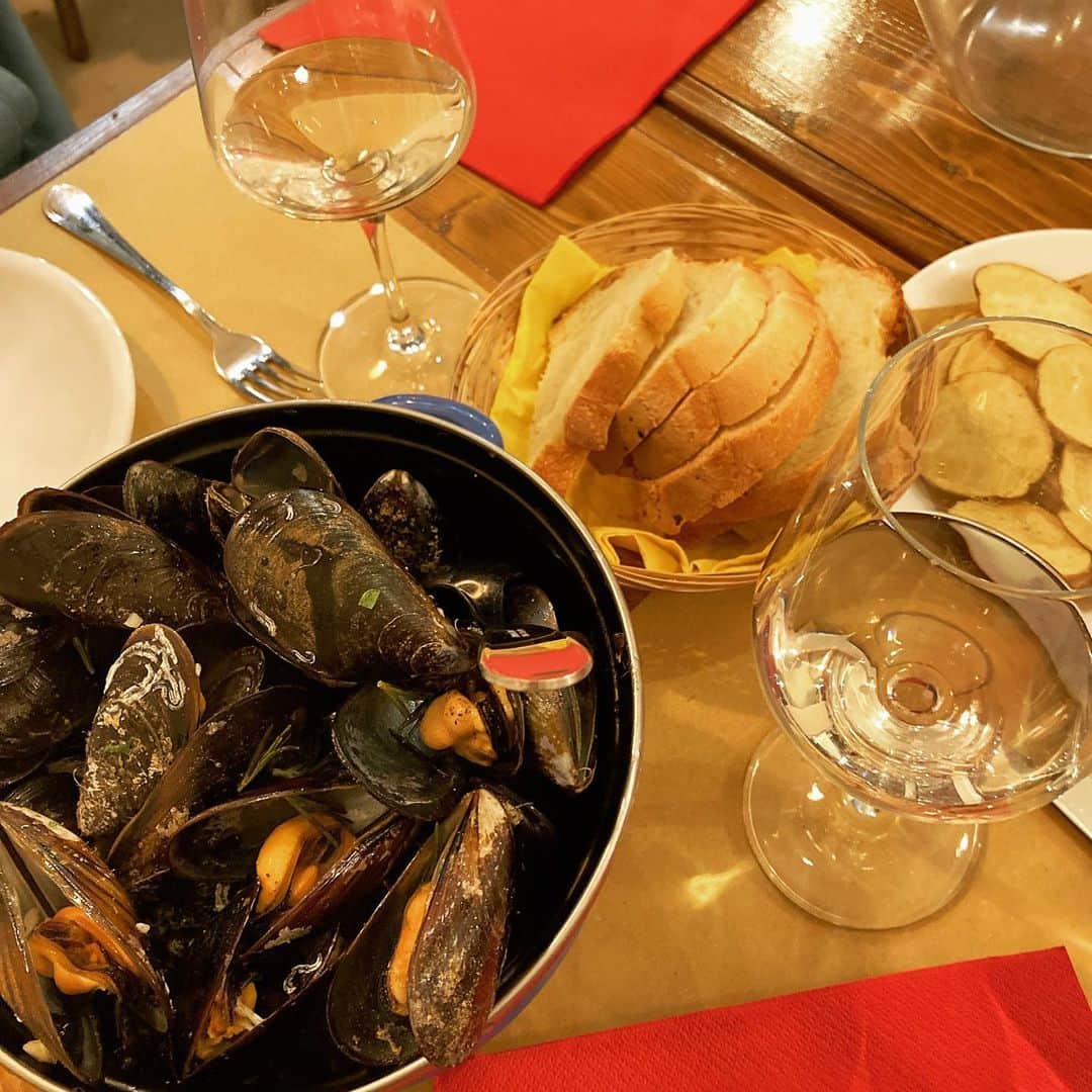 YUINAのインスタグラム：「. 4軒目🇮🇹 ⁡ La Cozzeria 楽しみにしてたイタリアの海鮮🦐🦪🐚 ⁡ ムール貝が絶品のお店😍✨１キロ🎉 ムール貝ならベルギーでしょ‼︎ってヨーロッパ経験者は思うはず🇧🇪😙 ⁡ ベルギーの白ワイン×セロリ×ムール貝とシンプルな味付けに対して イタリアのムール貝はローズマリーやガーリックやパセリとハーブが効いてて すごく華やかな香り😘🎉✨ ⁡ 繊細で洗練された味はゆっくり味わわないとわからないから、ゆったり流れる時間を楽しめて幸せすぎる🥹 ⁡ 繊細な味付けとは無縁で、レストランもほぼテラス席でご飯がタイムレースで冷えていくマルタやギリシャから来るともう感度マックス！笑 ⁡ ミラノはファッション、美食、 オペラ(飛行機遅れて間に合わず笑)と 欲のままに楽しめる大人の遊び場❤️ もう感じることしかできませんってくらい美味しくて美しい🎉 ⁡ メニューも読めず、おすすめくださいってでてきたワインも最高に美味しい〜🍾 ヨーロッパのワインはEUの規定で酸化防止剤が 日本のワインに入ってる量の1/3〜1/2レベルだから、変な酔い方しないし、ただただ美味しいを楽しめるよ🥹✨ ⁡ オイスターやエビと大好物があるお店を選んだのに、 すでにお腹いっぱいすぎてムール貝以外に何も食べれなかった。。笑 ⁡ ミラノは日数たっぷりとって来たいとこ😋 イタリアのマンマがムーミンママみたいな体型になるのが納得いく❤️ むしろ太りに行くとこ😘✨笑 ⁡ そんな時があってもいいよね😁  📍 La Cozzeria Via Pietro Calvi, 34, Milano  ⁡ #イタリア #ミラノグルメ #イタリアンシーフード」