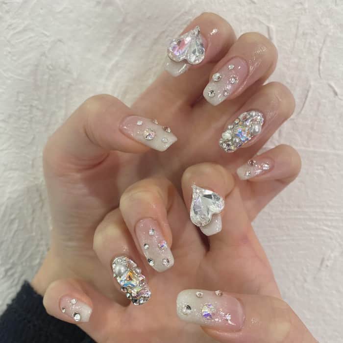 のインスタグラム：「お客様ネイル🍨🧊  ホワイトグラデーション+ストーンでおもいっきりキラキラなお手元に✨  埋め尽くしは不動の人気です♥︎  こちらは持ち込みデザイン120分コースです🪄  ありがとうございます(*´ω｀*)  @venusbelt_official  ご予約はこちら↑のプロフィールから承っております🧸 ケアのみ、フットもお待ちしてます🐾  #venusbelt_official  #ビーナスベルト　#ワンホンネイル　#キラキラネイル　#埋め尽くしネイル　#チークネイル　#白ネイル　#個性派ネイル　#ハートネイル　#ロングネイル #フラッシュネイル　#newnail #newネイル　　#渋谷ネイル　#アイブロウ　#マツエク　#まつ毛パーマ　#eyelash  #ロイッシュカラー  #カラーエクステ #ブラウンマツエク #パリジェンヌラッシュリフト #まつげパーマ #eyebrows #アイブロウwax #nails  #ネイルデザイン #トレンドネイル #shibuya #サブスク」