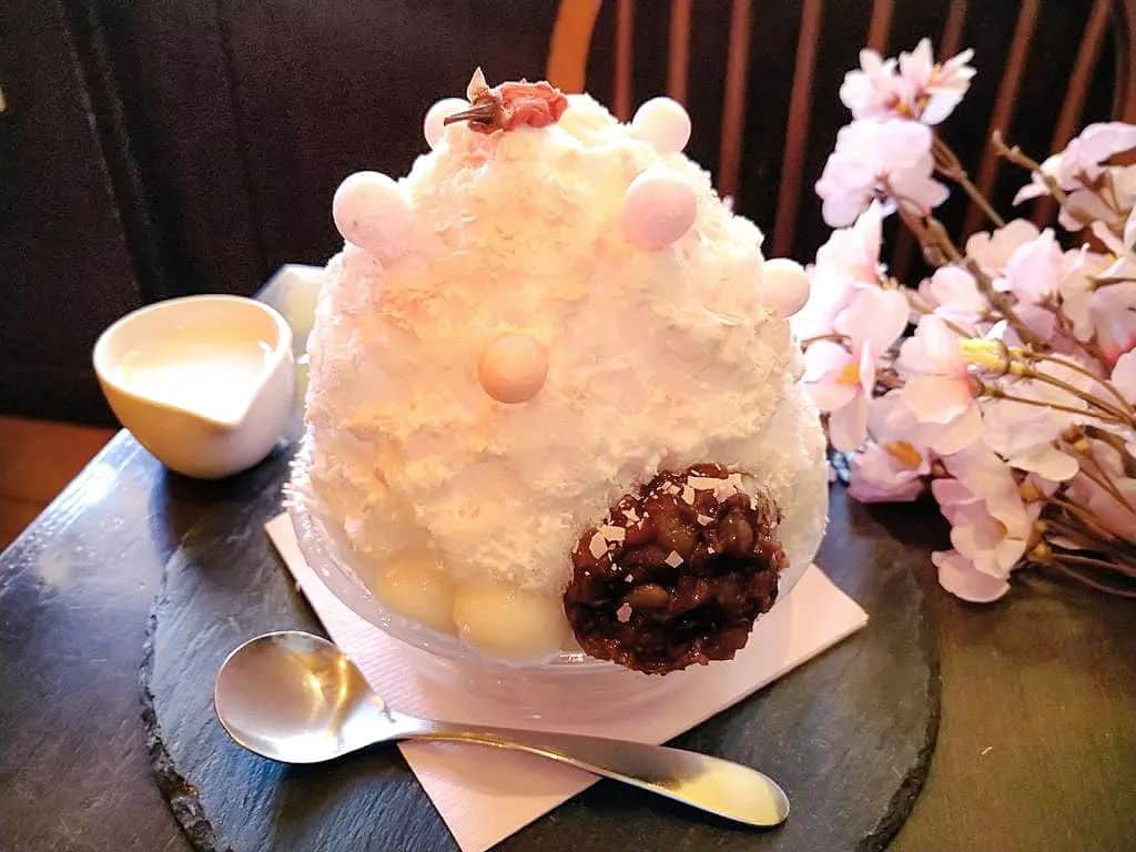 おいもカフェ金糸雀のインスタグラム：「. ふわり食感の氷の春限定「桜かき氷」(税込900円)。春香る桜クリームを全体にかけ、桜餅をイメージした白玉と小豆をトッピング。上にはピンクのおいりと桜の塩漬けを飾り付け、周りにスライスした桜チョコを振り掛けて桜吹雪を演出。氷の中にはサプライズの桜アイスを忍ばせ、最後まで桜を楽しめます♪ . #おいもカフェ金糸雀 #おいもカフェ #鎌倉 #小町通り #湘南 #神奈川 #カフェ #喫茶店 #甘味処 #鎌倉カフェ #湘南カフェ #神奈川カフェ #鎌倉スイーツ #鎌倉グルメ #桜かき氷 #かき氷 #桜 #さくら #サクラ #桜味 #桜スイーツ #さくらスイーツ #春スイーツ #ピンク #かわいい #カフェ巡り #スイーツ巡り #喫茶店巡り #kamakura #가마쿠라 . 《おいもカフェ金糸雀》 営業時間：10:00-18:00(L.O.17:30) 定休日：水曜日 248-0006 神奈川県鎌倉市小町2-10-10 小町TIビル1F TEL：0467-22-4908」