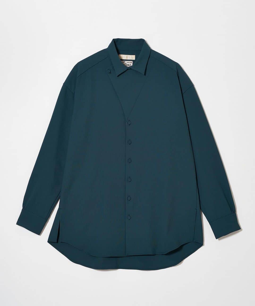 メアグラーティアのインスタグラム：「meagratia 23SS Flap shirt col. grn  襟元のデザインが特徴的なワイドシャツ。襟元のフラッ プは開けて着ることも閉めて着ることもできる2way仕様 です。ややシャリ感がありドライタッチのポリエステル オックスを使用しています。 同素材のパンツ23231-0602とのセットアップもおすすめ です。  material Polyester 100%  #meagratia #23ss」