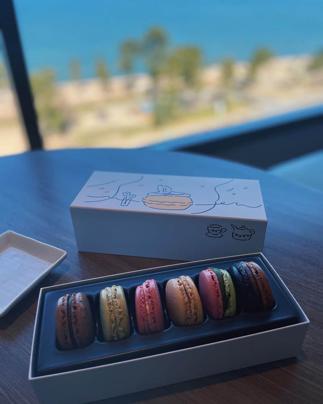 わちみなみのインスタグラム：「サロンドショコラからスイーツ熱が、、🍫  ピエールエルメの可愛いパッケージに一目惚れ🤍アーティスト長場雄さんとのコラボ。  新しいホワイトデーの提案で バレンタインデーのお返し、自分へのギフト、 この時期らしく新たな門出を祝うものとして。 3種類あったので、私は自分へのギフト🍋 (イラストが好みだったので)  中のマカロンも春らしいパッとした色でとても心晴れやかな気持ちになりました🤍  2枚目。 食べてみたかったパレドオール！ 東京駅に立ち寄れたので、、。 ベルナシオンで修行を積んだ三枝俊介氏による ショコラ🍫 私は特にカシスとキャラメル、定番のパレドオールに心惹かれました。 サロンドショコラから情報交換しているお友達とシェアしました。 1人で食べるのも良いけど、 2人で感想を言いながら食べるのも楽しい🍋  #ホワイトデー #ギフト #スイーツ　#チョコレート」