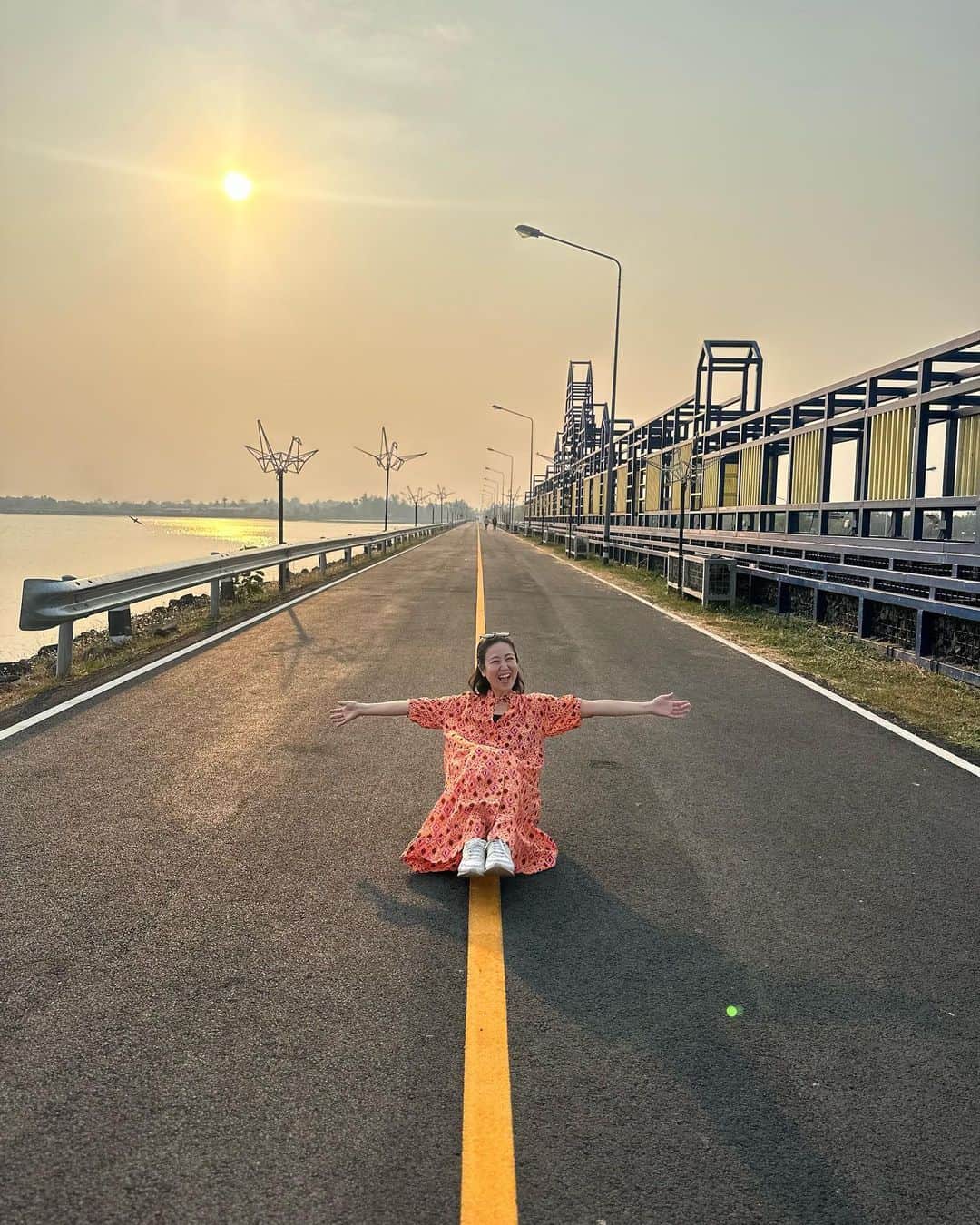 のインスタグラム：「ブリラムの貯水池サンセット🌅 バンコクとは違って空気がゆっくり流れてた☺️咳も止まったよ❗️  タイ人は写真ポーズが上手だね💕と言ったら『そこに座って〜お花を持って〜キスして〜』と誘導してくれた😍それなのに、花を鼻に突っ込もうとしてゴメン‼️5555  #buriram #sunset #ブリラム #サンセット #貯水池」